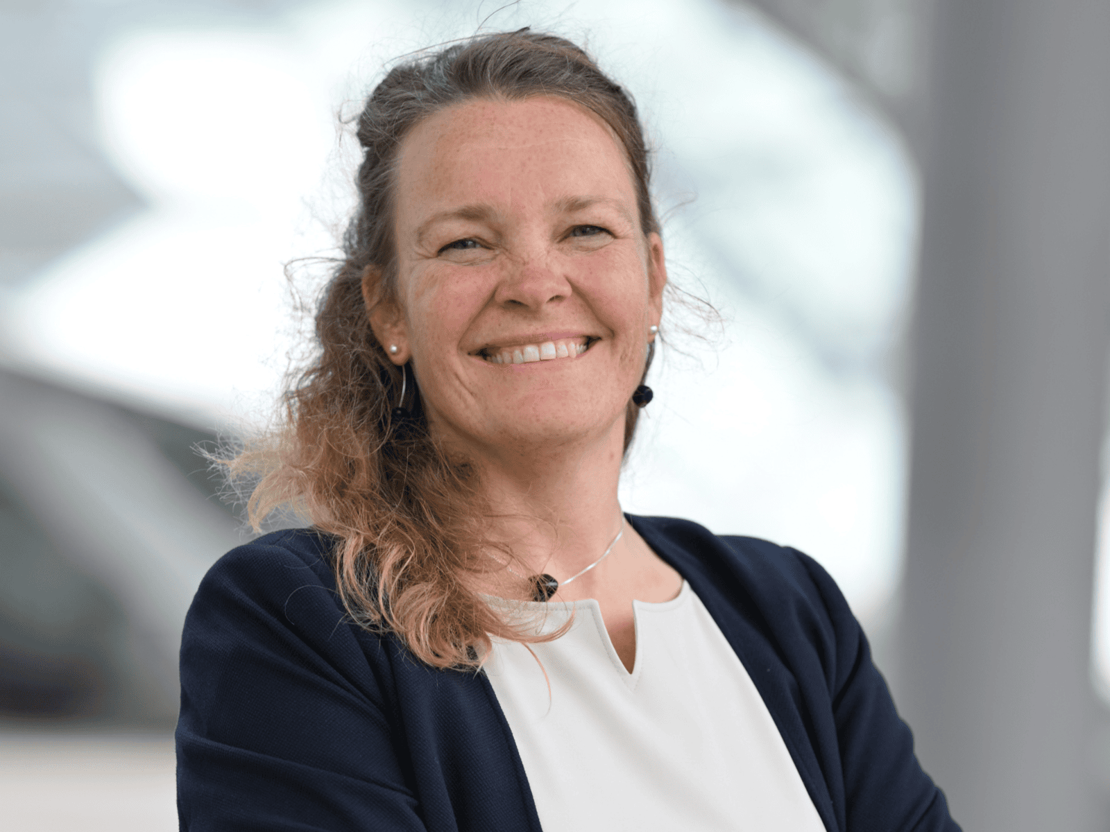 Eine Frau schaut in die Kamera und lacht.