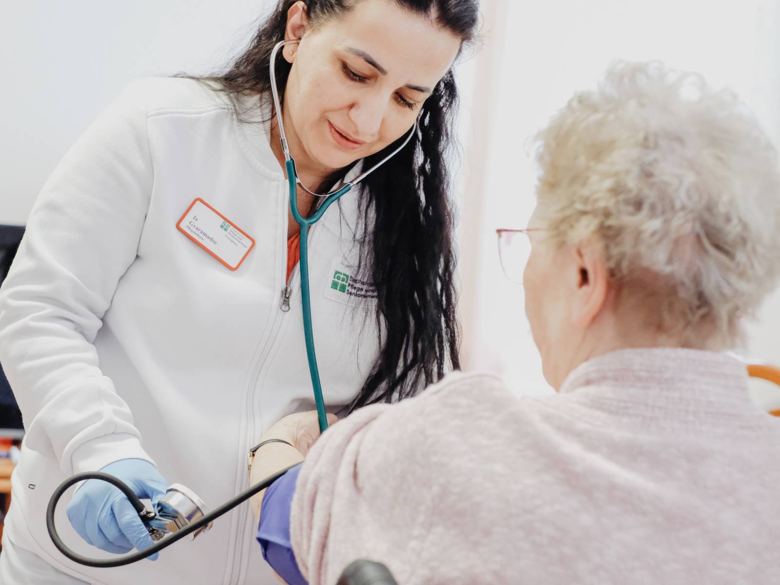 Eine Frau misst den Blutdruck bei zweiten Frau