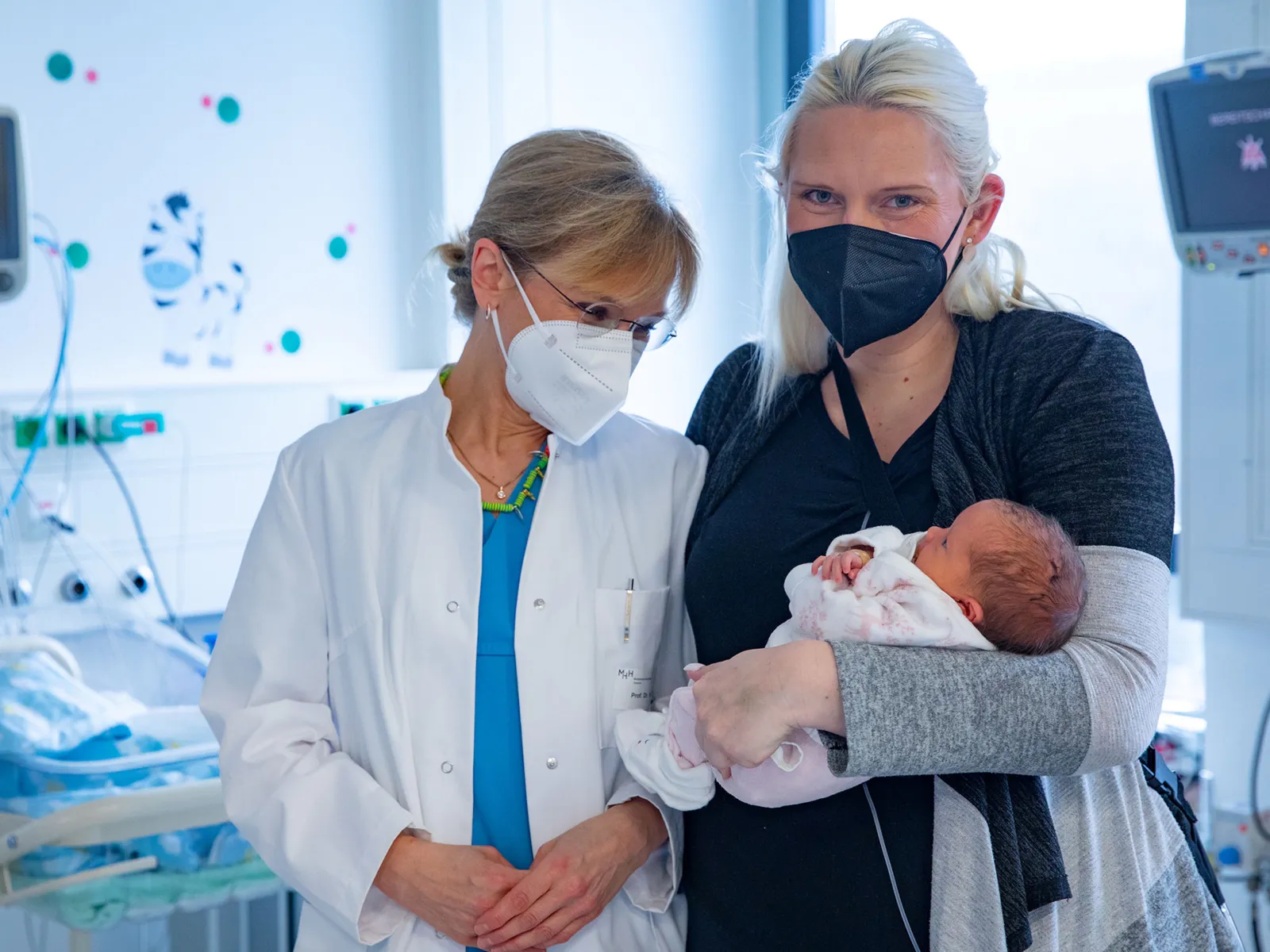 Zwei Frauen, eine hält einen Säugling auf dem Arm
