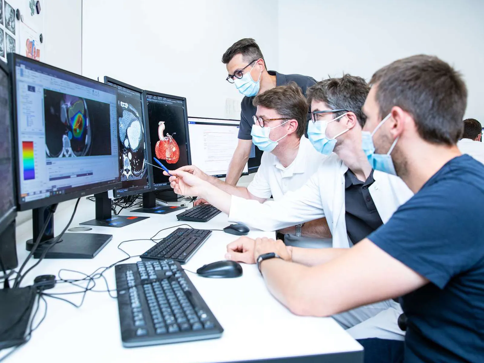 Ärzteteam blickt auf Computermonitore.