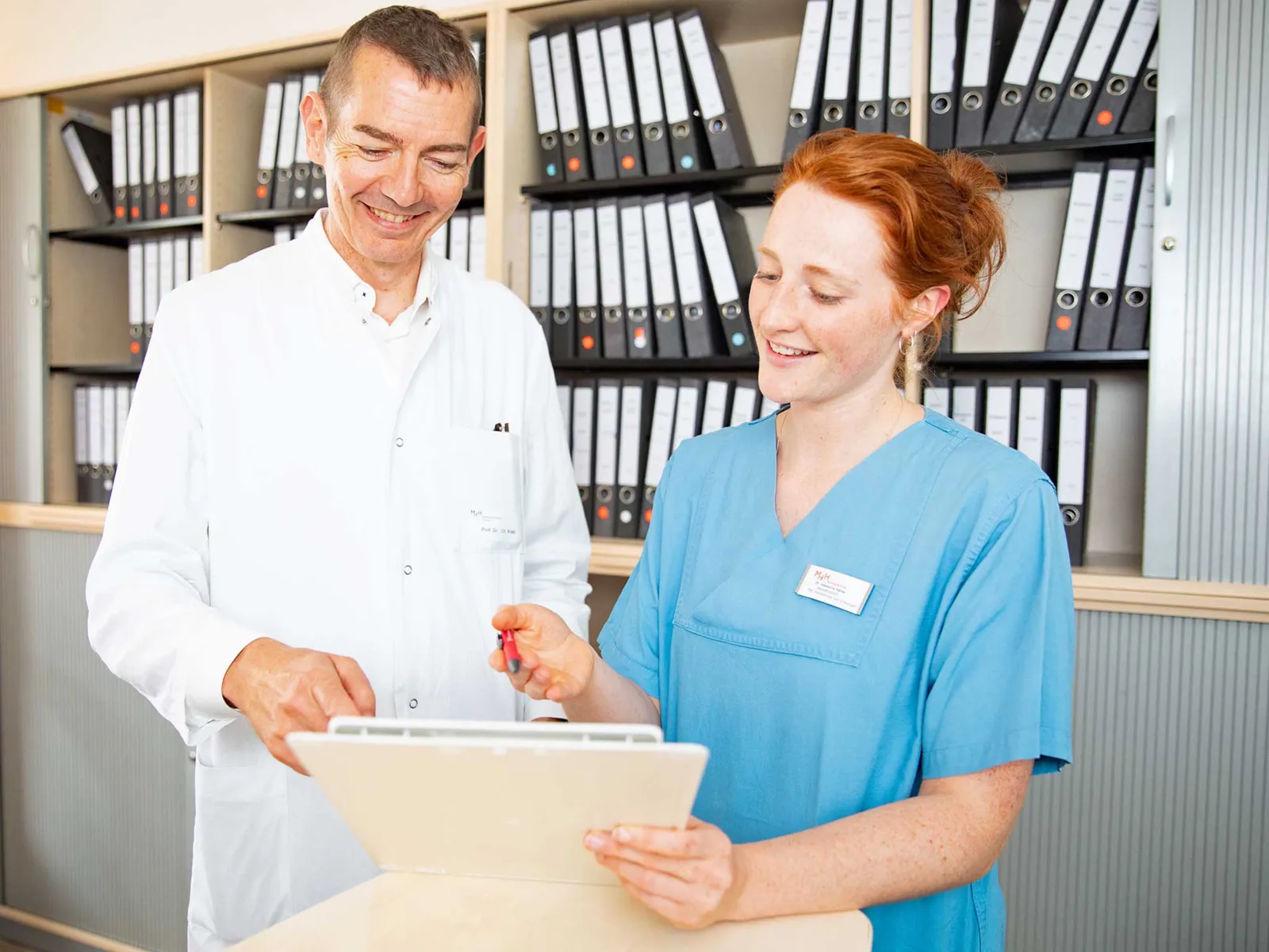 Ein Mann und eine Frau in medizinischer Arbeitskleidung.