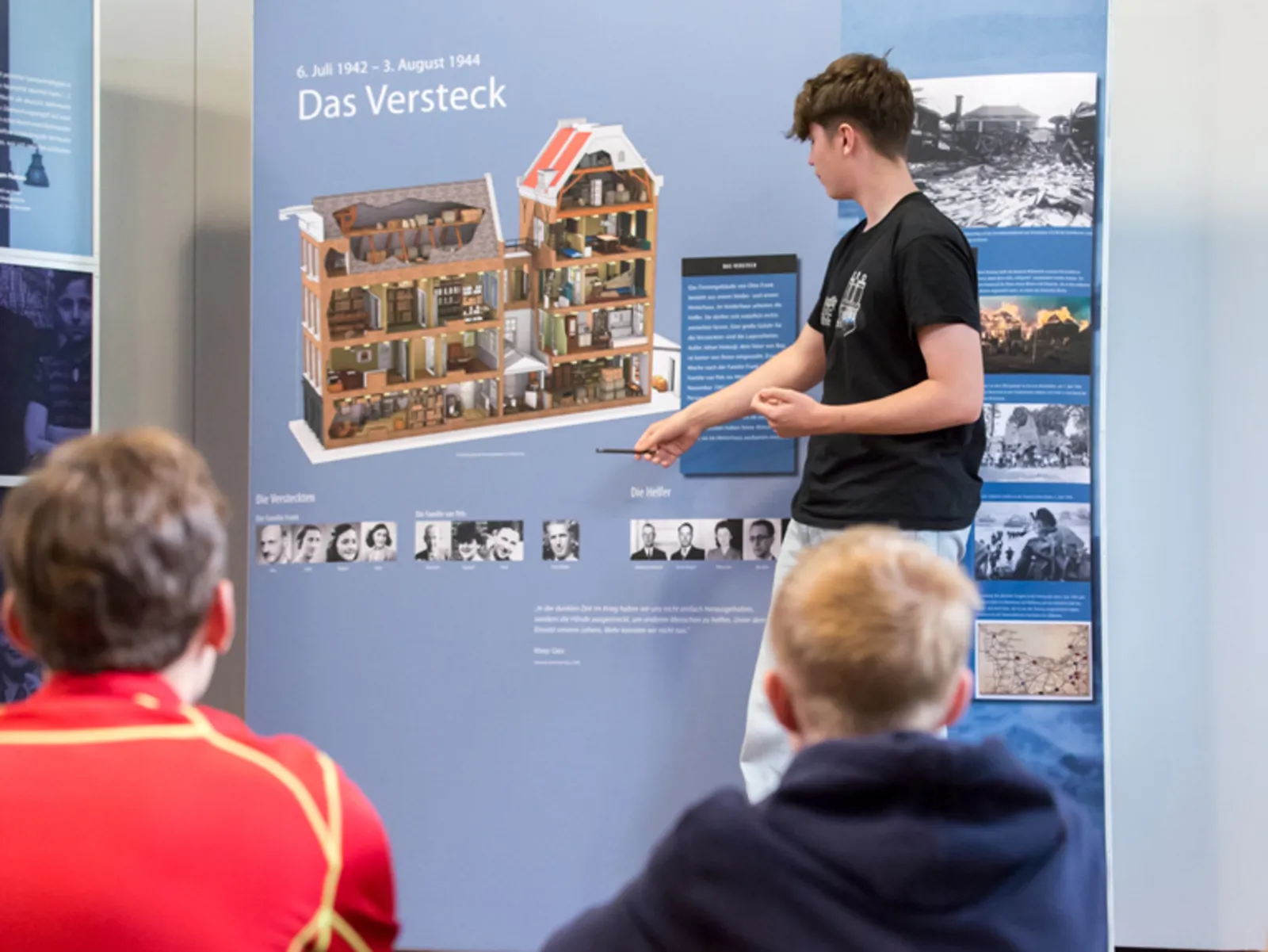 Jugendliche besch&auml;ftigen sich mit der Infotafel einer Ausstellung