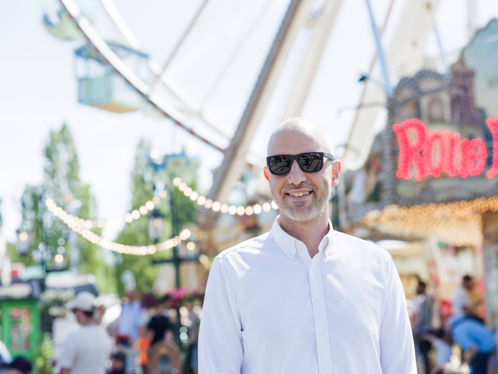 Ein Mann mit einer Sonnenbrille auf einem Festplatz.