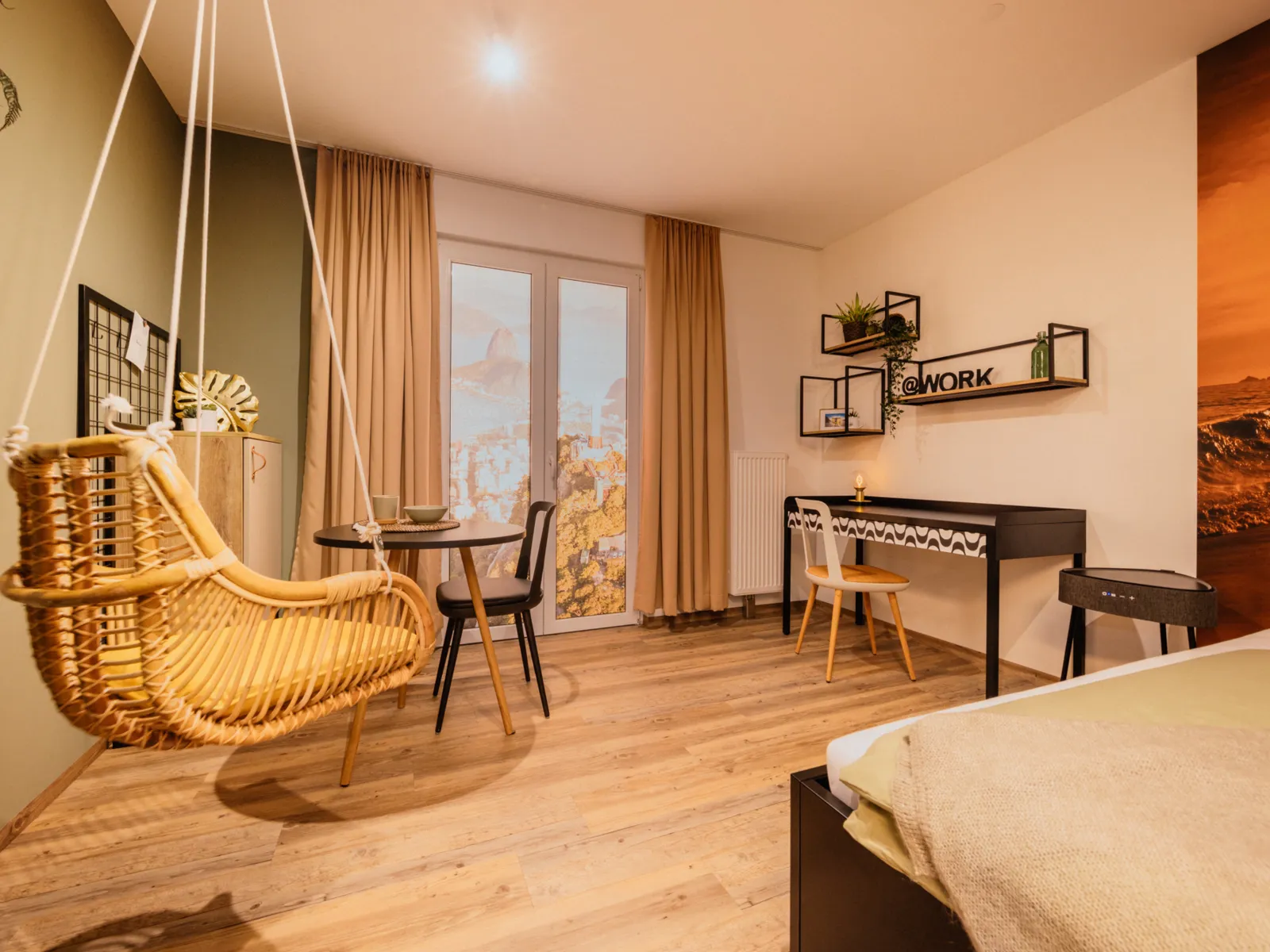 Zimmer mit Bett, H&auml;ngestuhl, Arbeitsplatz und Bett.