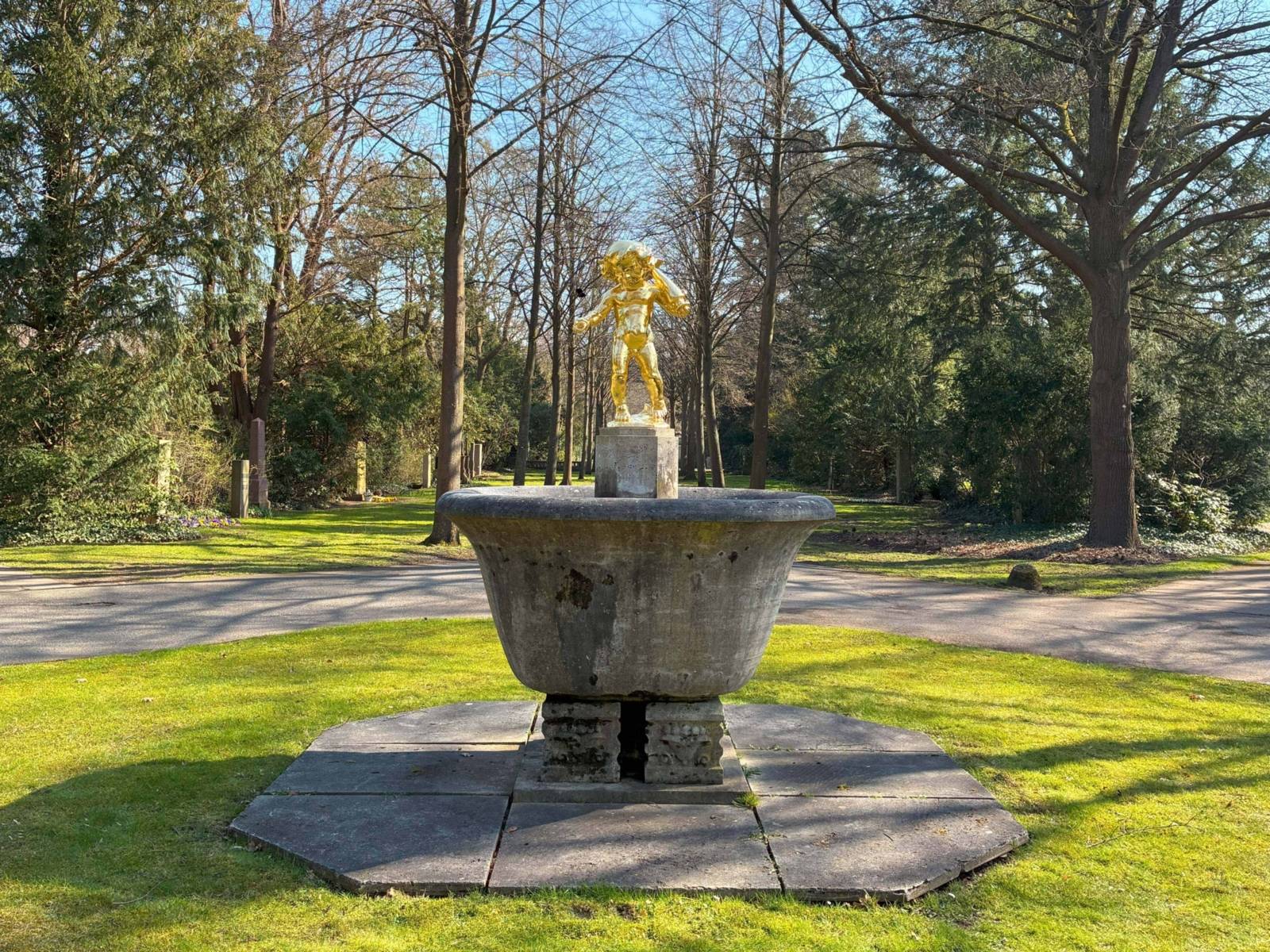 Skulptur eines goldenen Engels auf einem Friedhof.