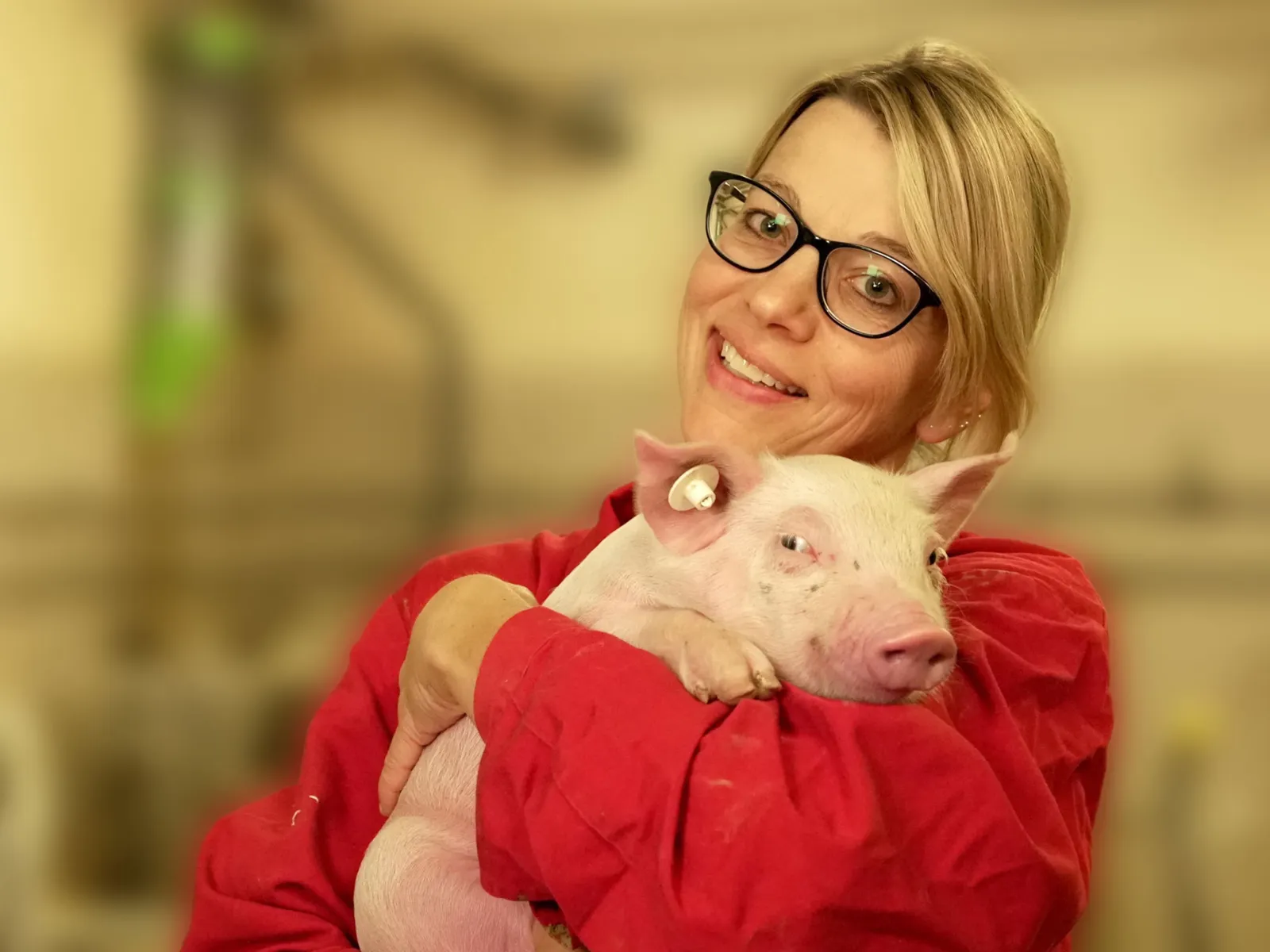 Frau mit Ferkel auf dem Arm.
