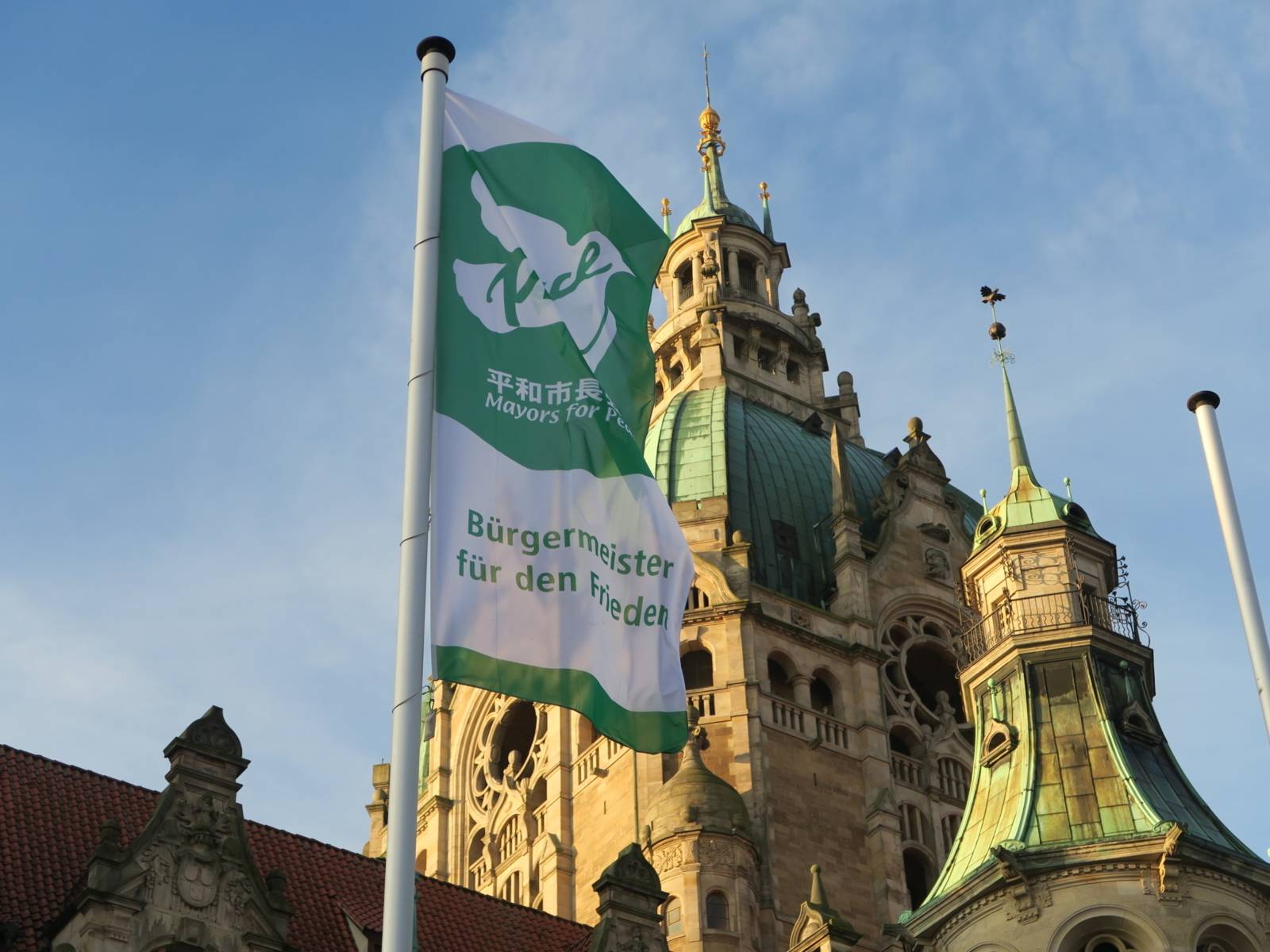 Die Flagge der "Mayors for Peace" weht im Wind, vor dem Neuen Rathaus in Hannover.