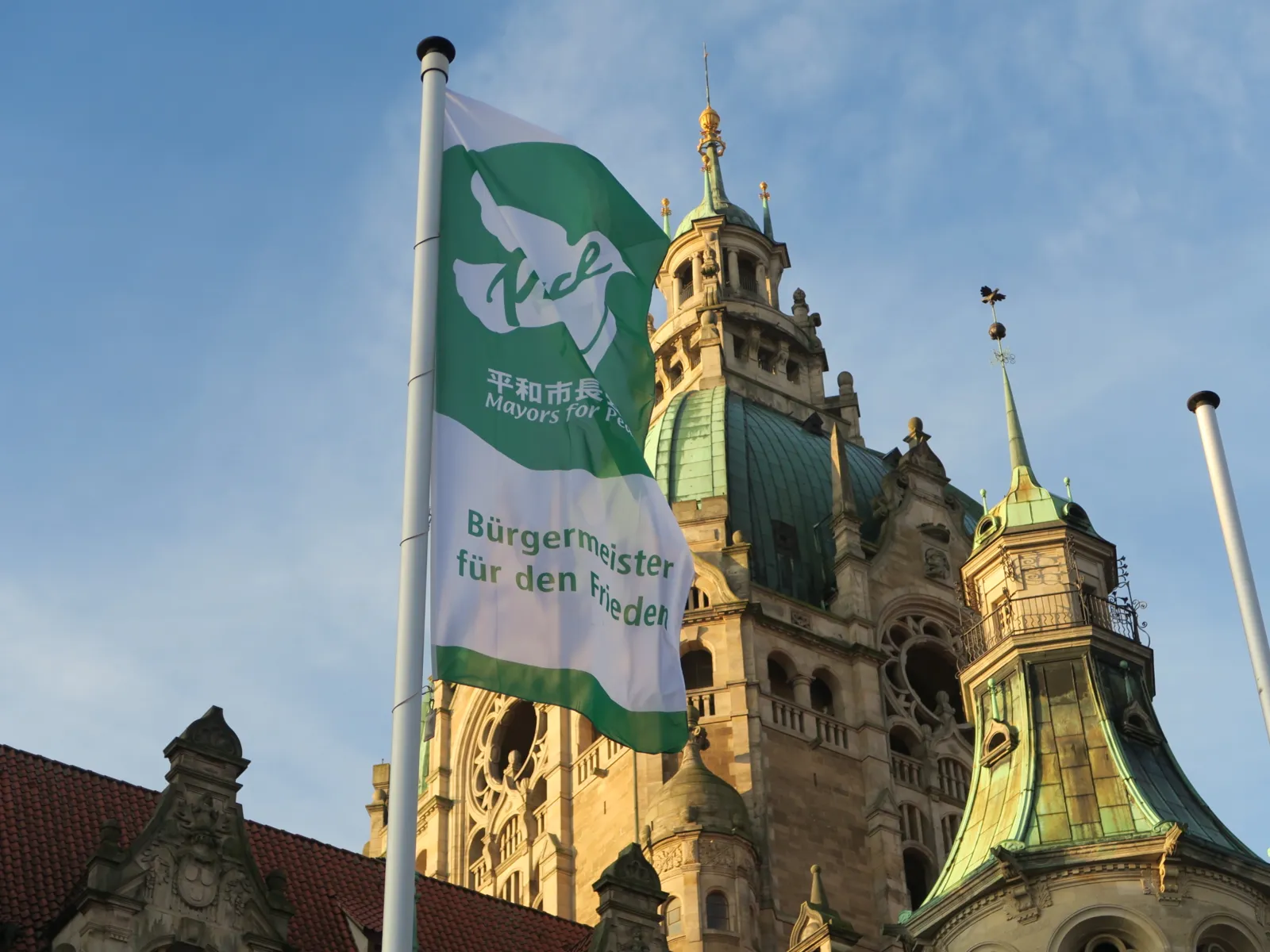 Die Flagge der "Mayors for Peace" weht im Wind, vor dem Neuen Rathaus in Hannover.