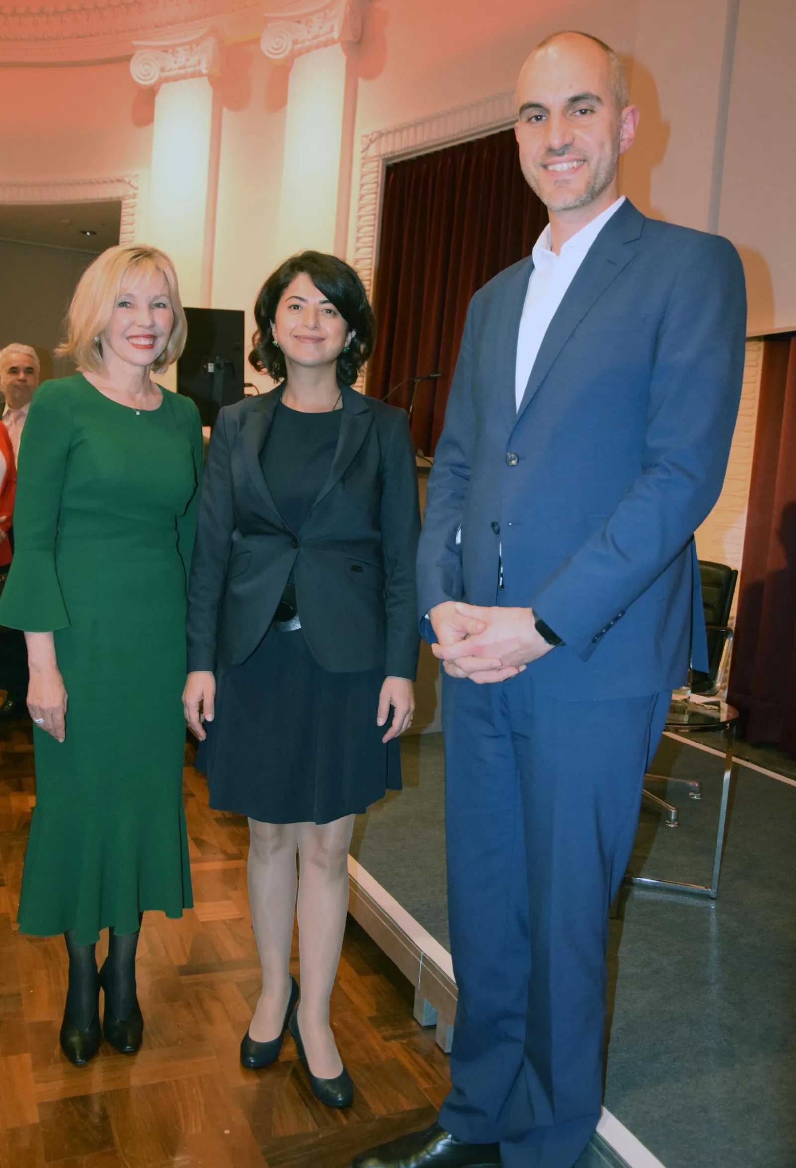 Zwei Frauen und ein Mann l&auml;cheln in die Kamera.