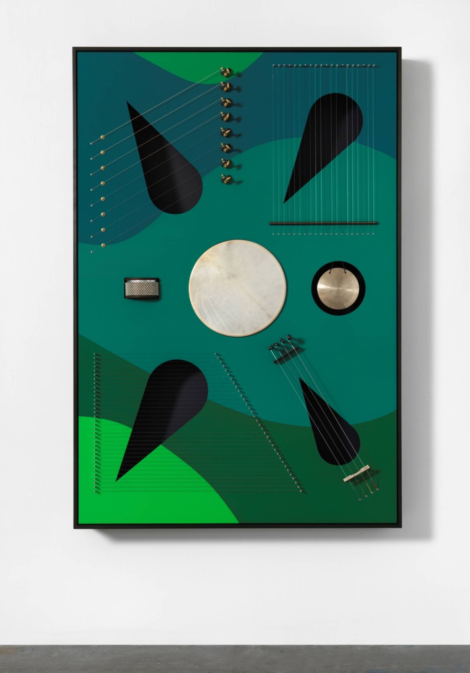 Zu sehen ist eine Skulptur von Nevin Aladağ: Ein gr&uuml;n gemaltes Rechteck aus Holz ist mit Saiten bezogen. Andere Elemente erinnern an Saiteninstrumente.