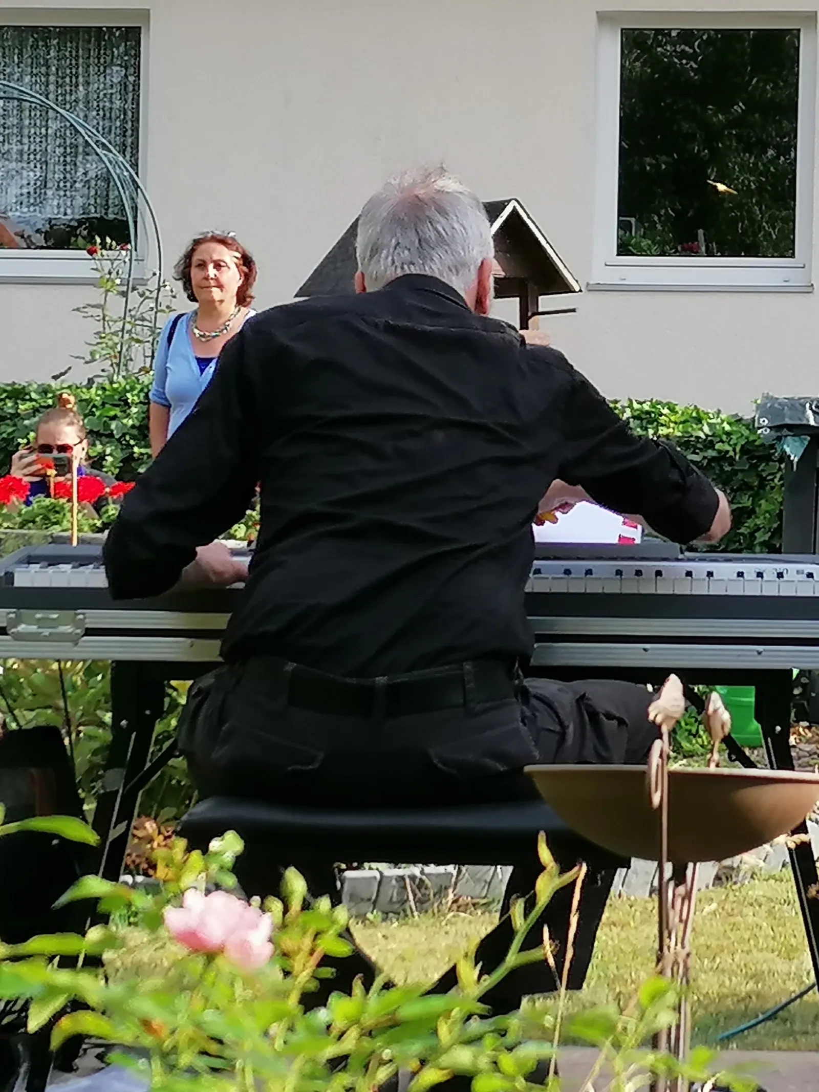 Mann spielt E-Piano im Garten