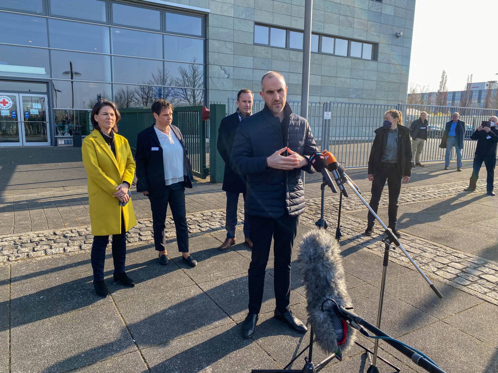 Mehrere Personen im Gespräche mit Pressevertretenden.