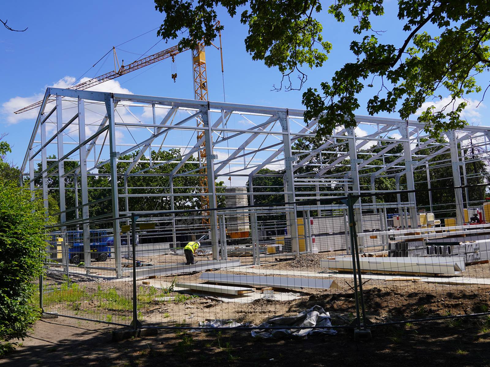 Eine Baustelle mit einem gro&szlig;en Metallger&uuml;st vor blauem Himmel.