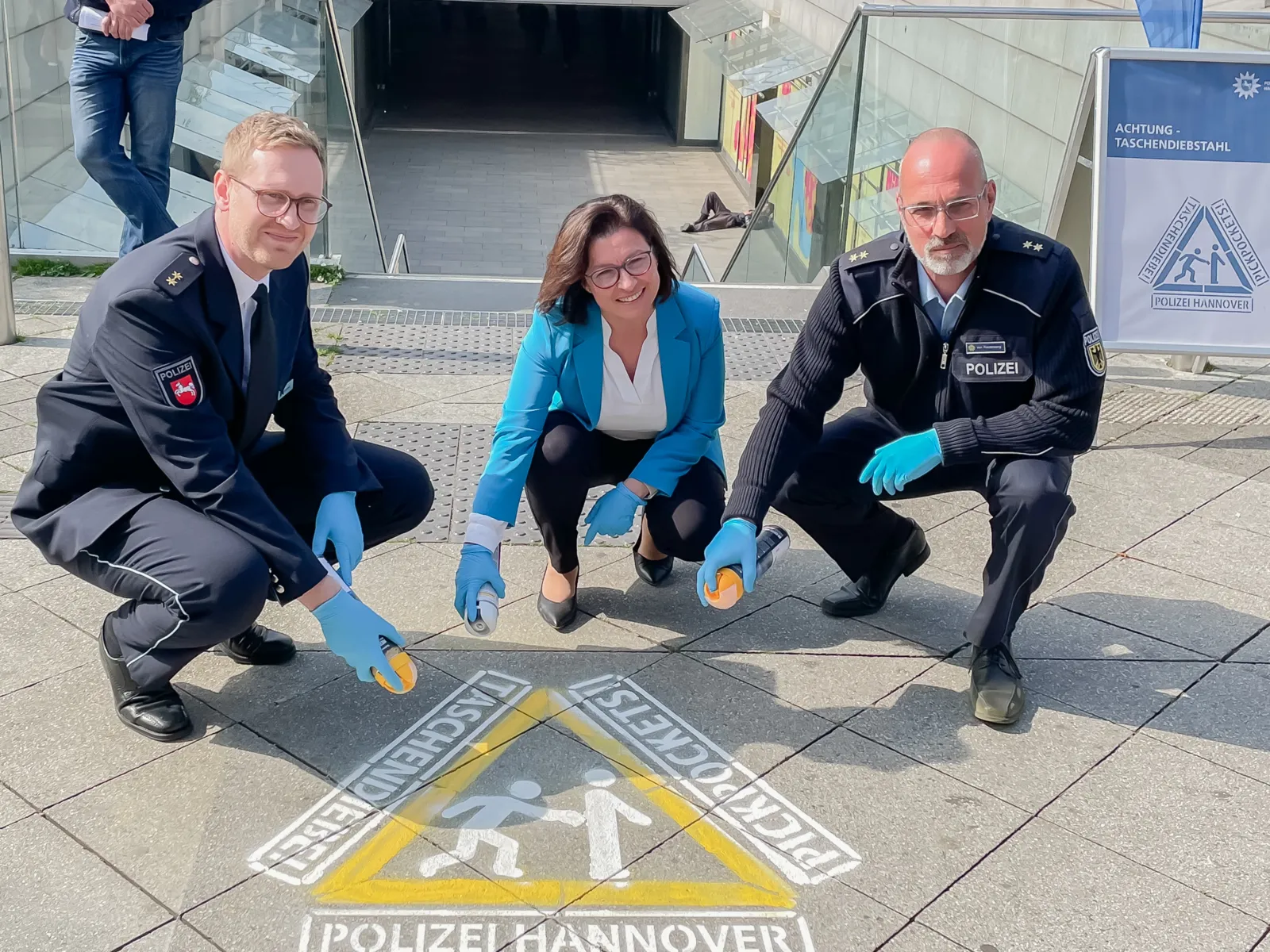 Drei Personen stehen um ein Symbol herum.