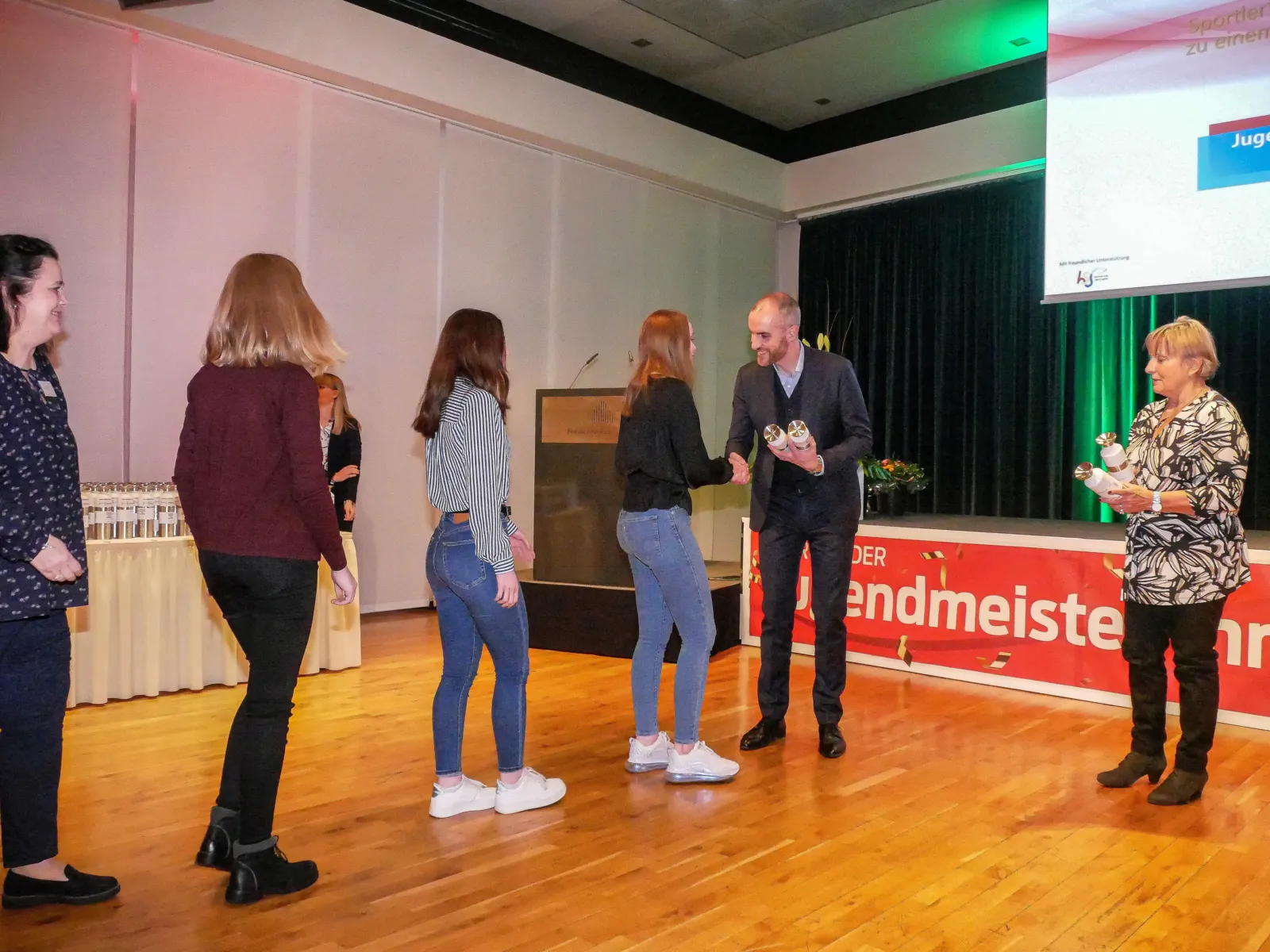 Mehrere Personen bei einer Auszeichnung. Der Oberbürgermeister schüttelt einer jungen Frau die Hand und gratuliert.