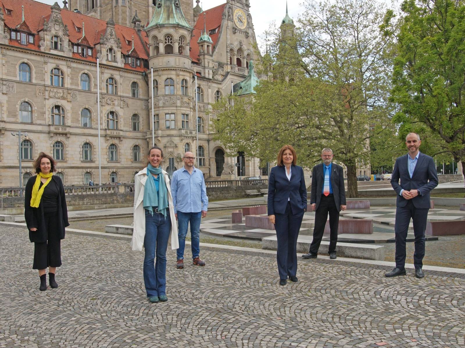 Drei Frauen und drei Männer vor dem Neuen Rathaus.