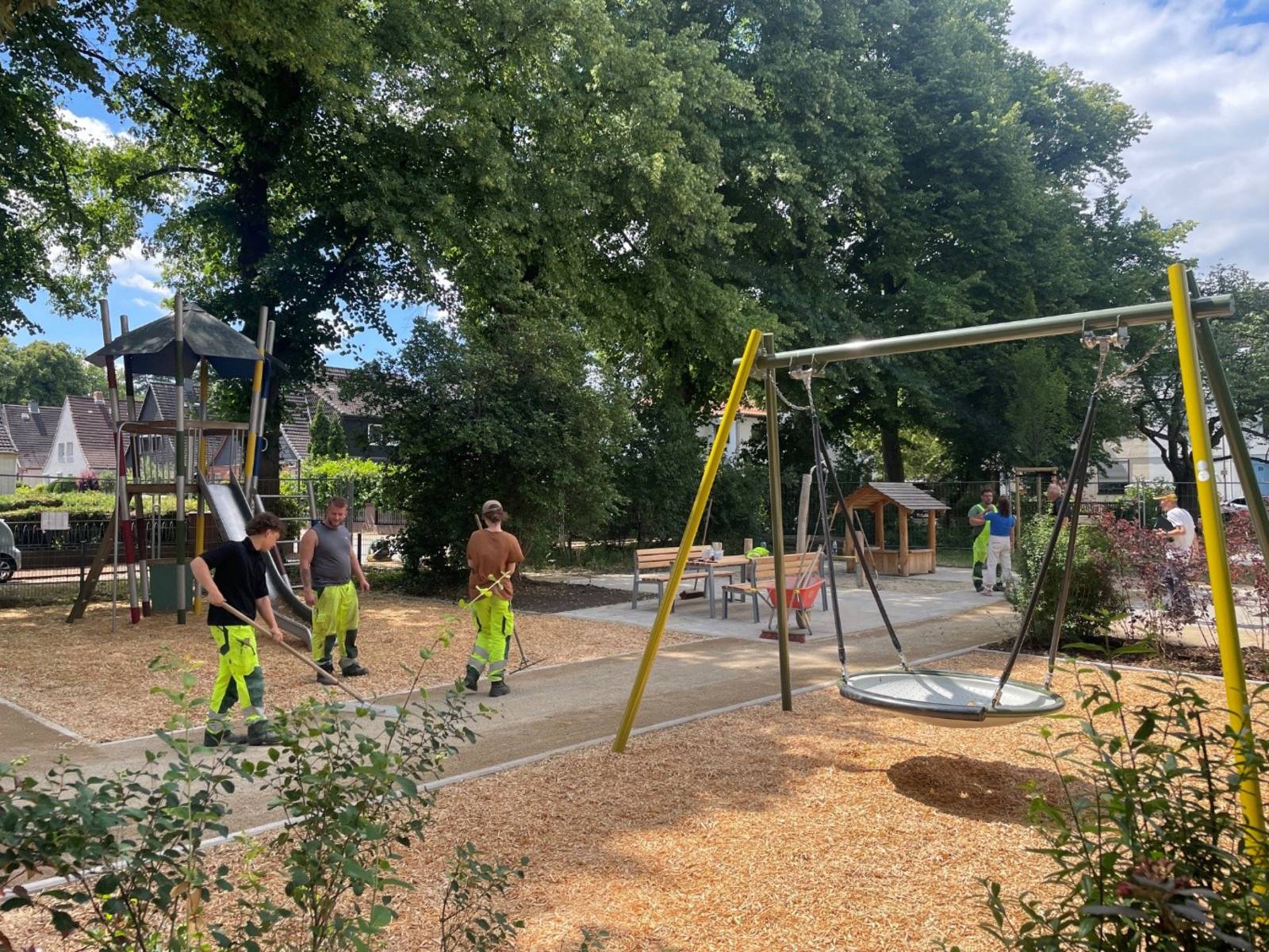 Personen auf einem Spielplatz, die letzte Arbeiten ausführen.