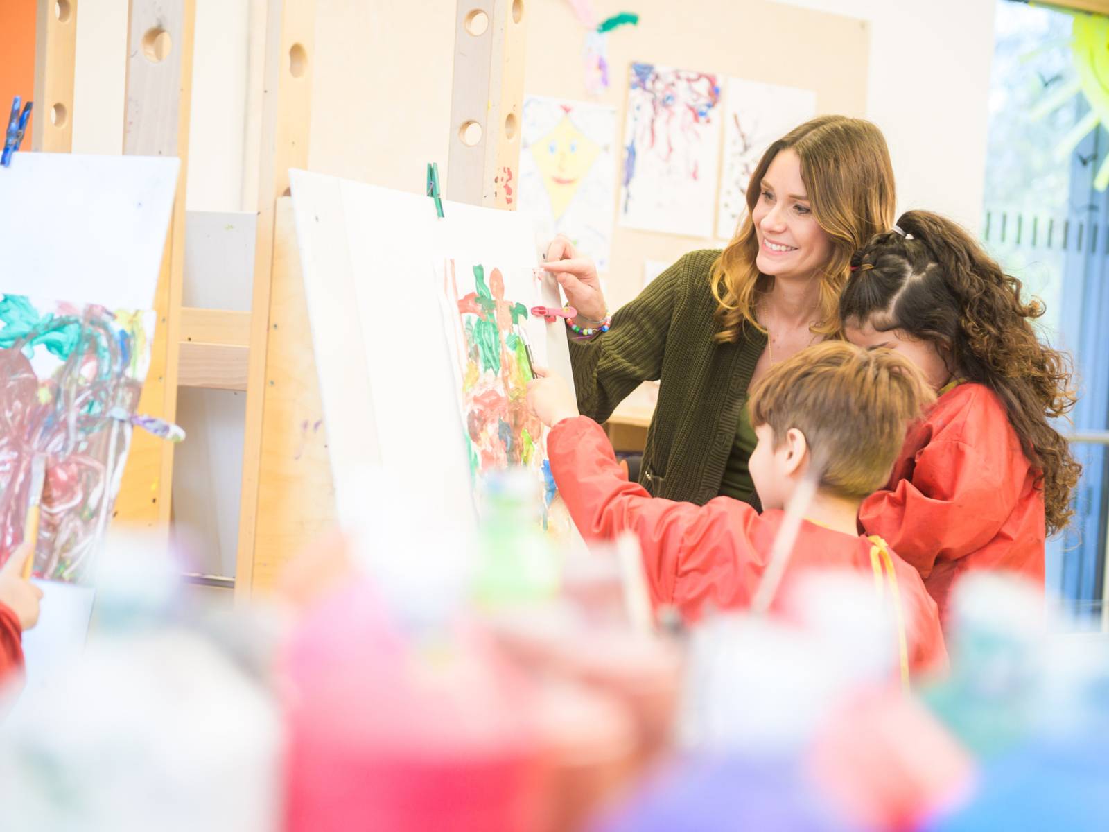 Erzieherin malt gemeinsam mit Kindern