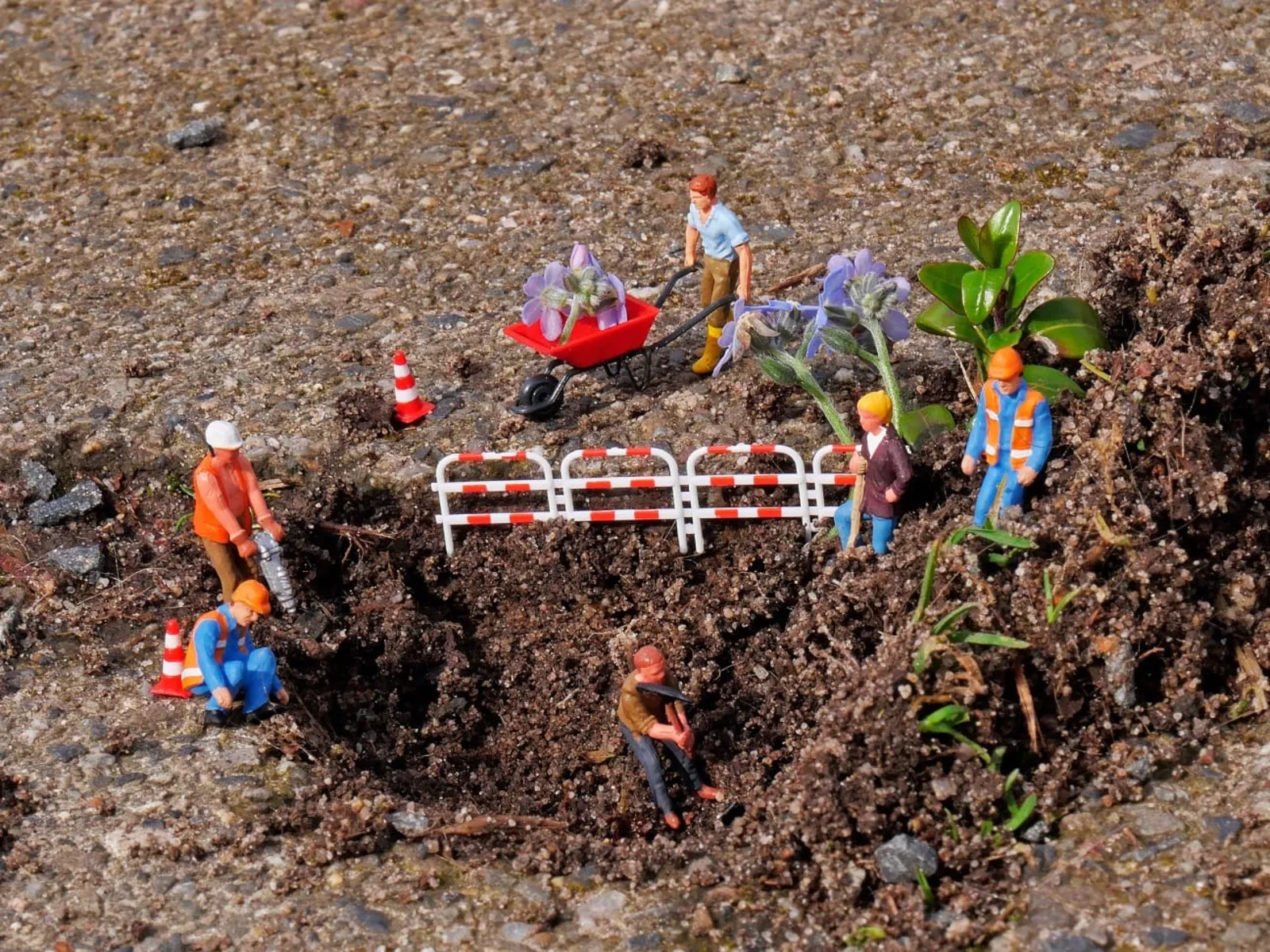 Mit Spielzeugfiguren und Blumen sowie Gräsernnachgebildete Baustelle