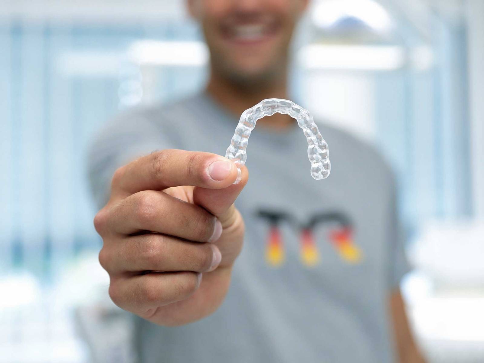 Mann hält Zahnimplantat in der Hand.