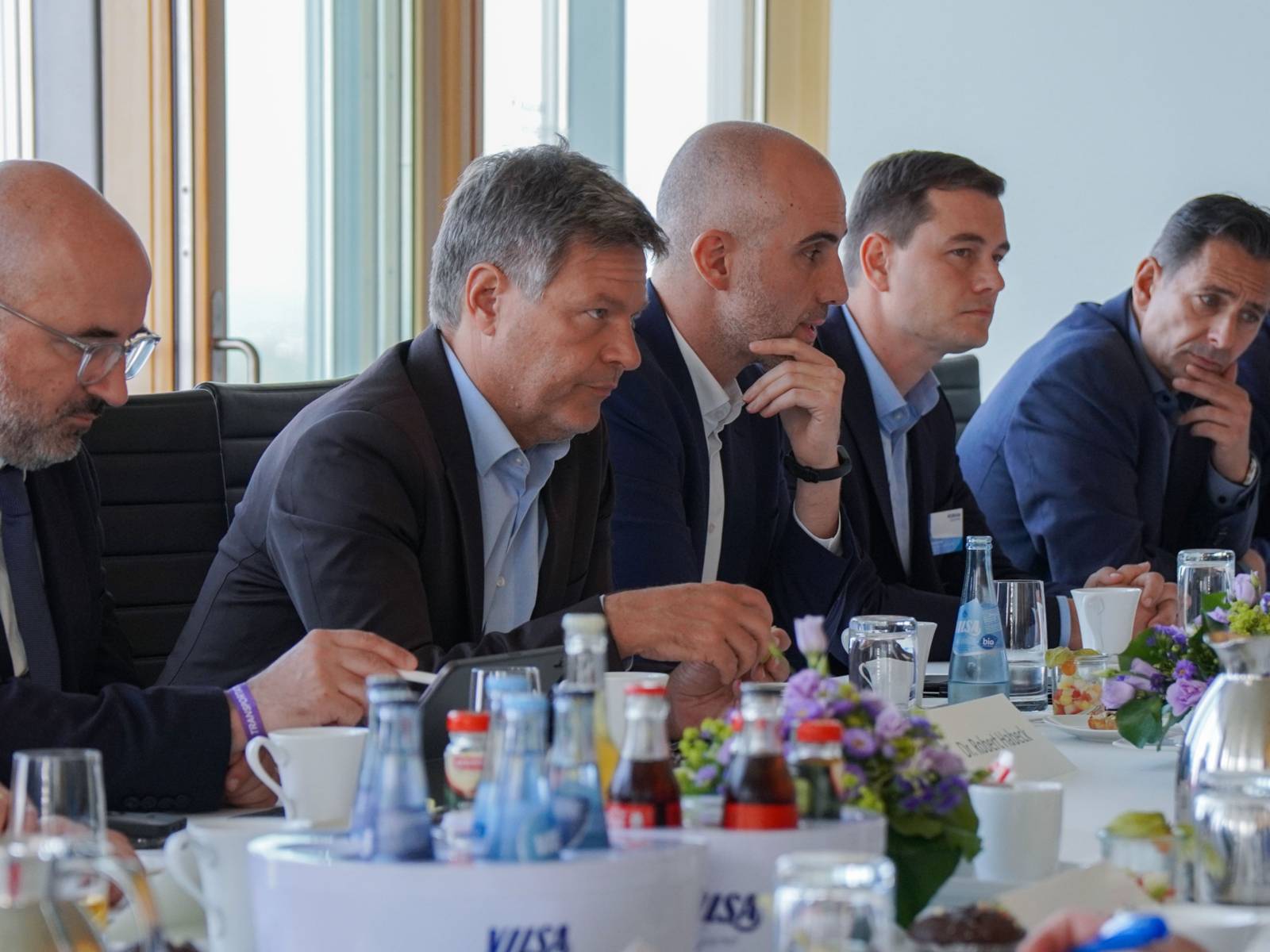 Mehrere Personen an einem Tisch im Gespräch.