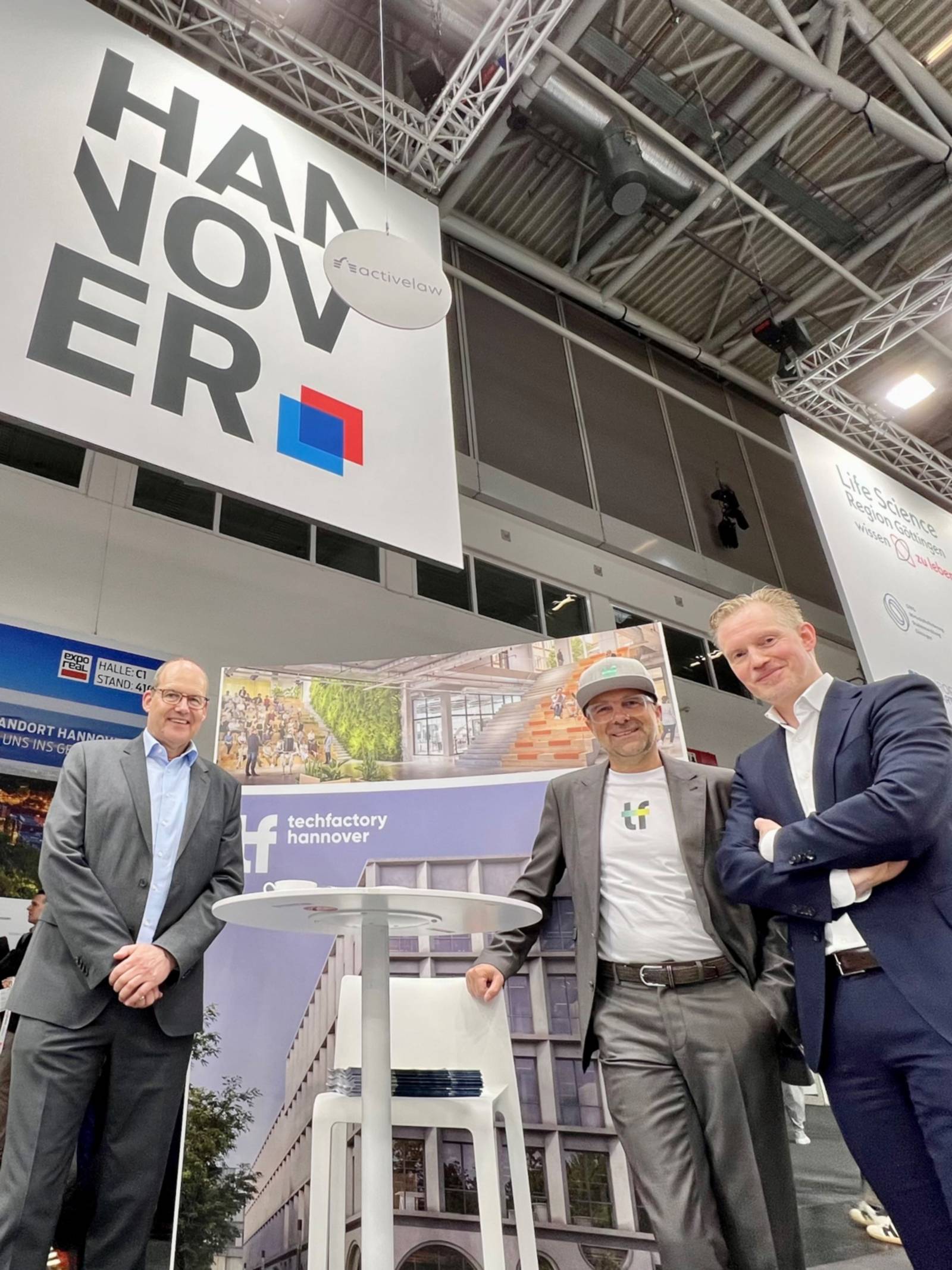 Drei Personen stehen vor einem Messestand