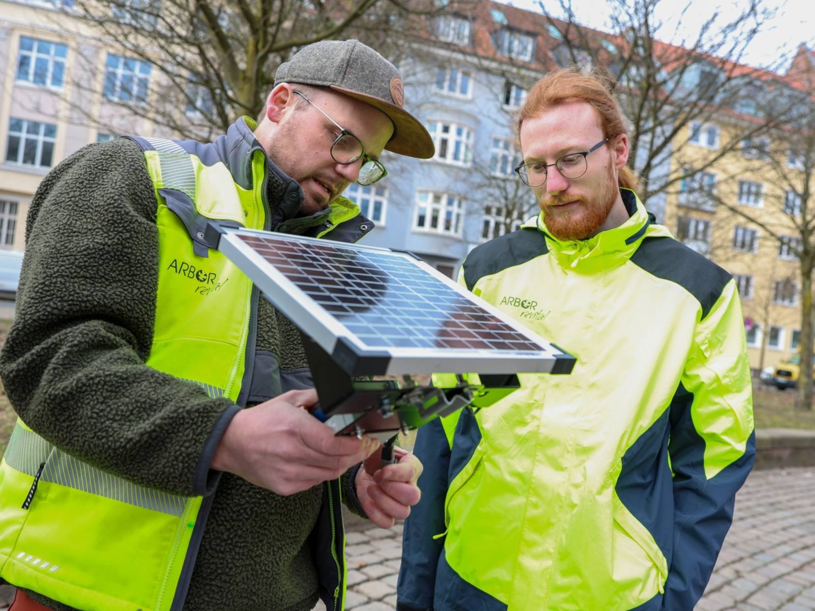 Zwei Männer mit einem Solarmodul.