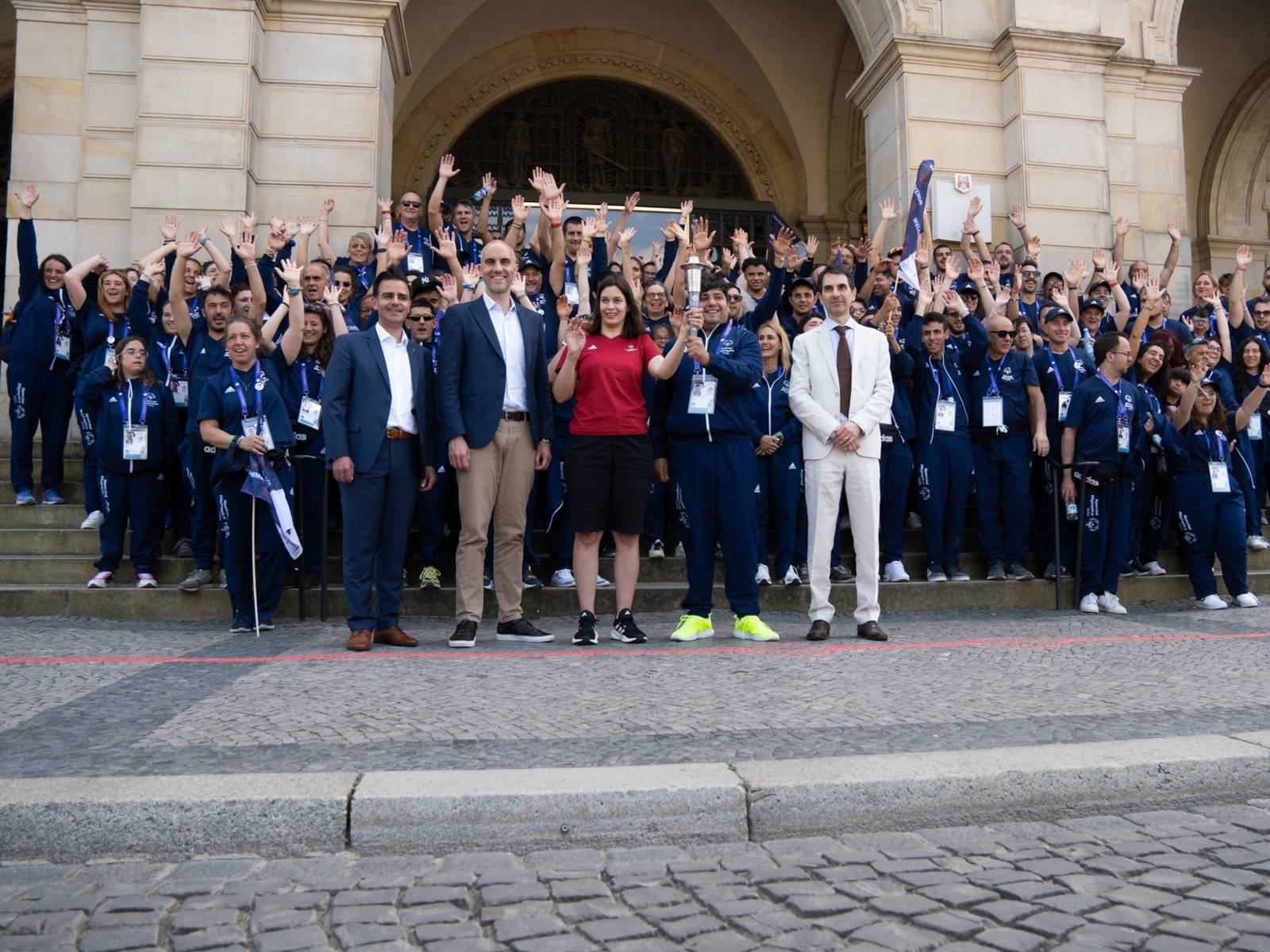 Gruppenfoto mit zwei Fackel-Träger:innen auf der Treppe vor dem Neuen Rathaus: Die Landeshauptstadt Hannover hat als Host-Town die Delegation der Special Olympics empfangen.
