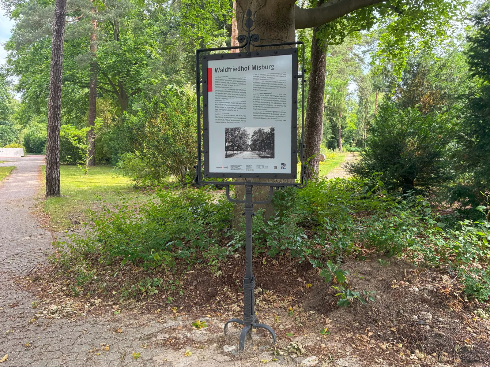 Ein Schild mit Informationen zu einem Friedhof.