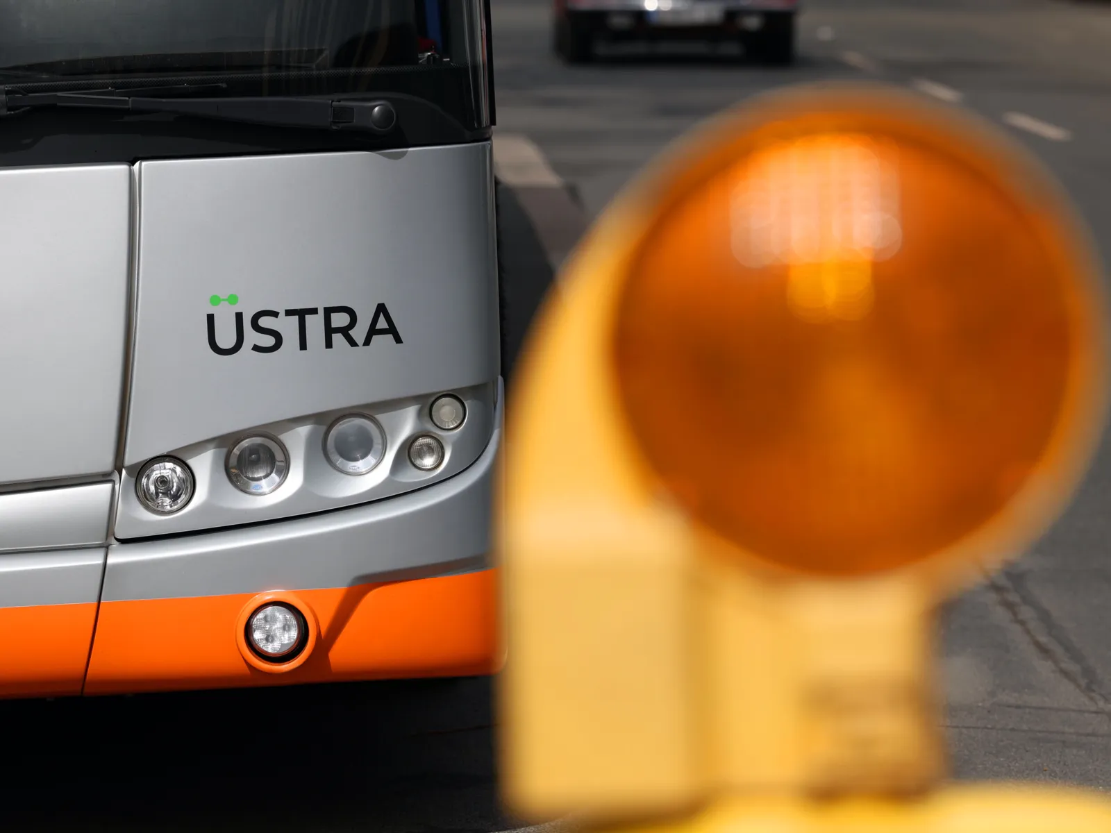 Eine Bake steht zur Markierung vor einem Bus