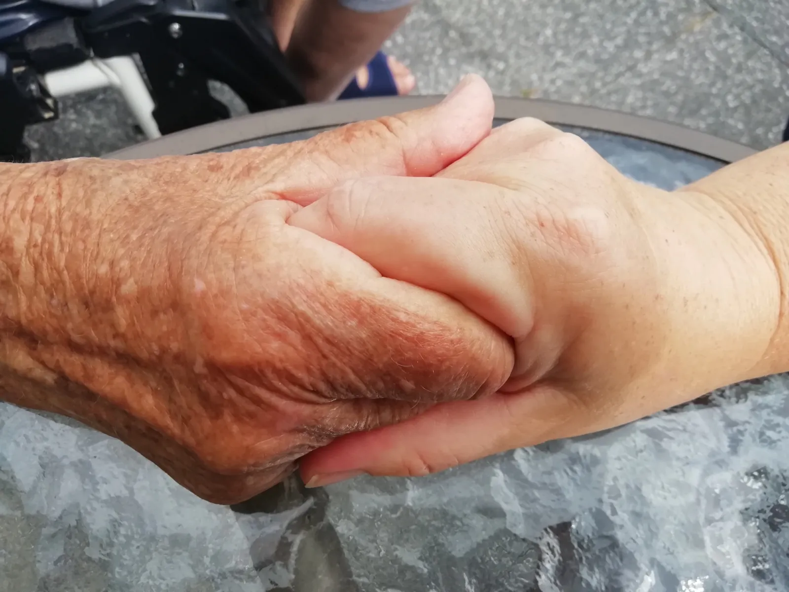 Die Hände einer jüngeren Person, die die Hände einer älteren Person halten