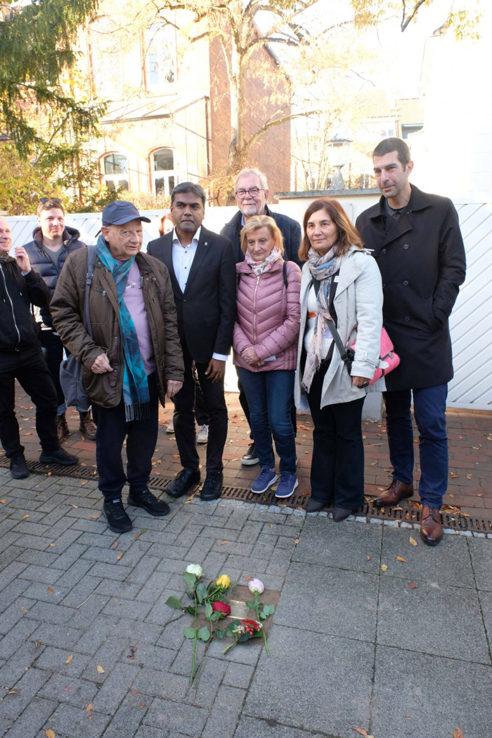Berni Stephanus (links) vor dem Stolperstein für seine Großmutter Dunia Schwarzmann mit Vertreter*innen der Stadt Hannover