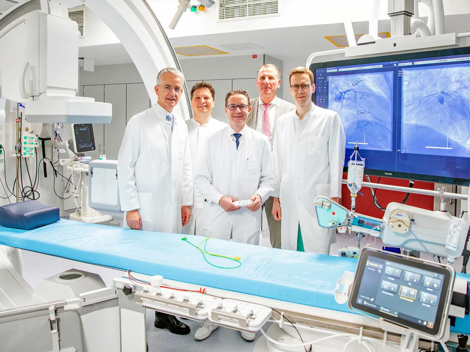 Fünf Männer stehen an einer Herzkatheteranlage.