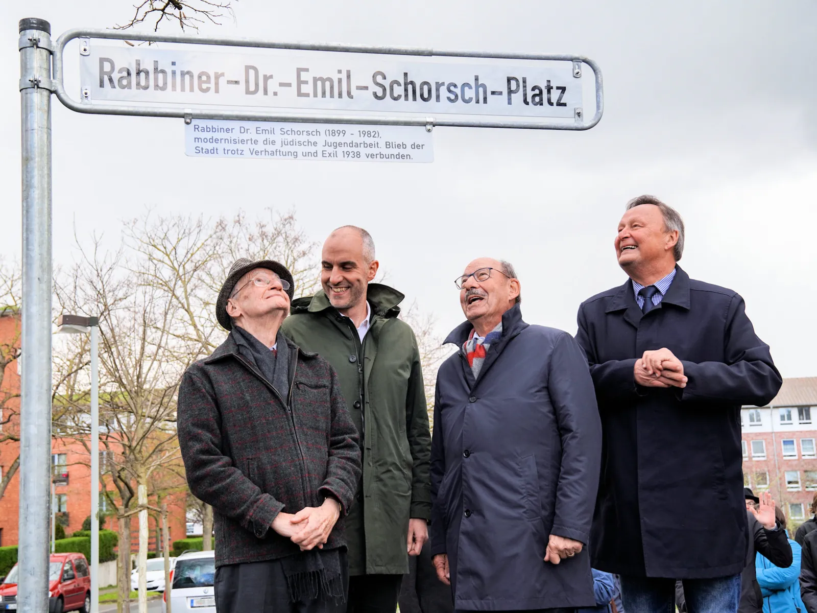 Fünf Personen bei der Enthüllung eines Straßenschildes.