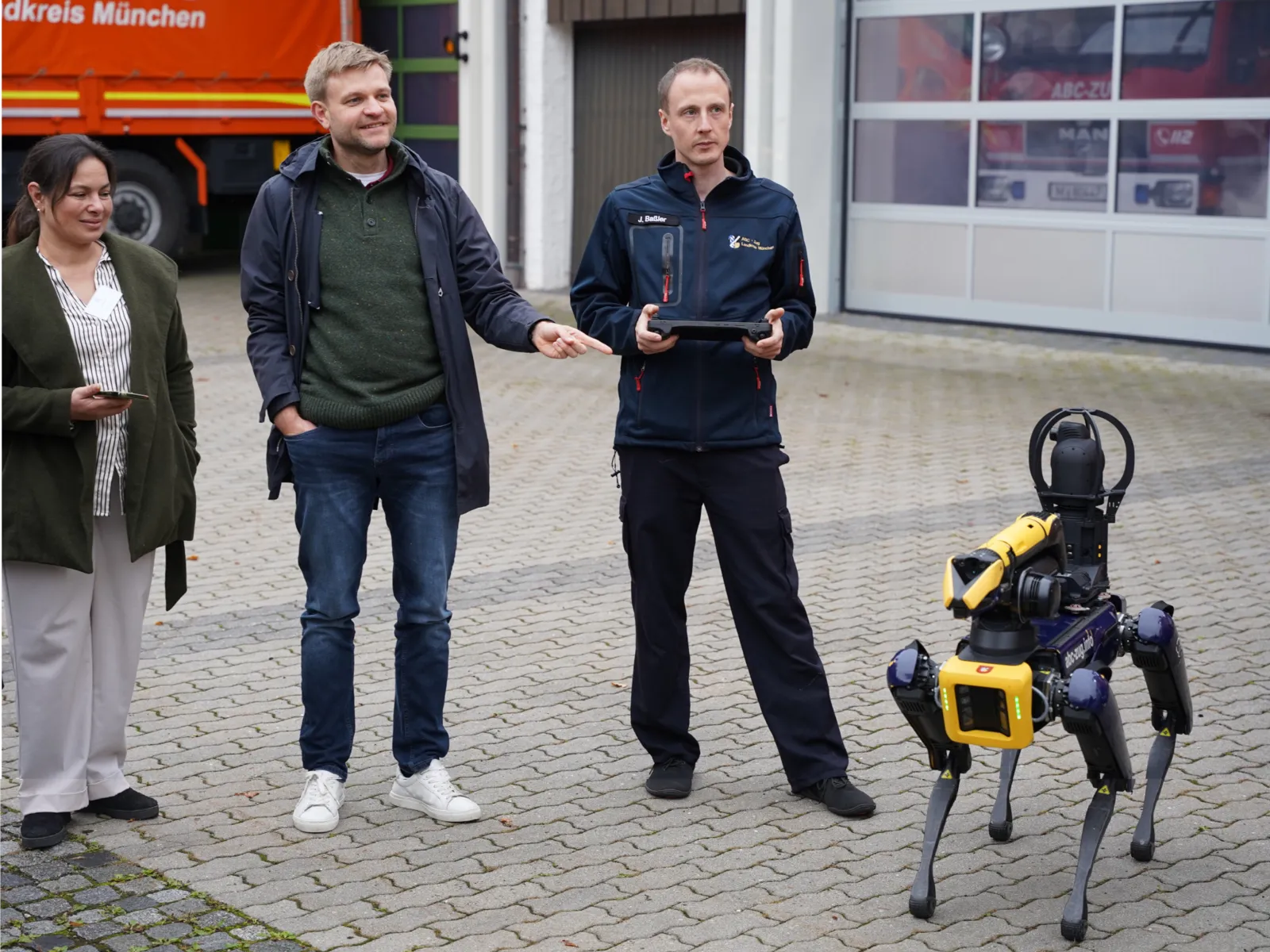 Drei Personen und eine Art Roboterhund
