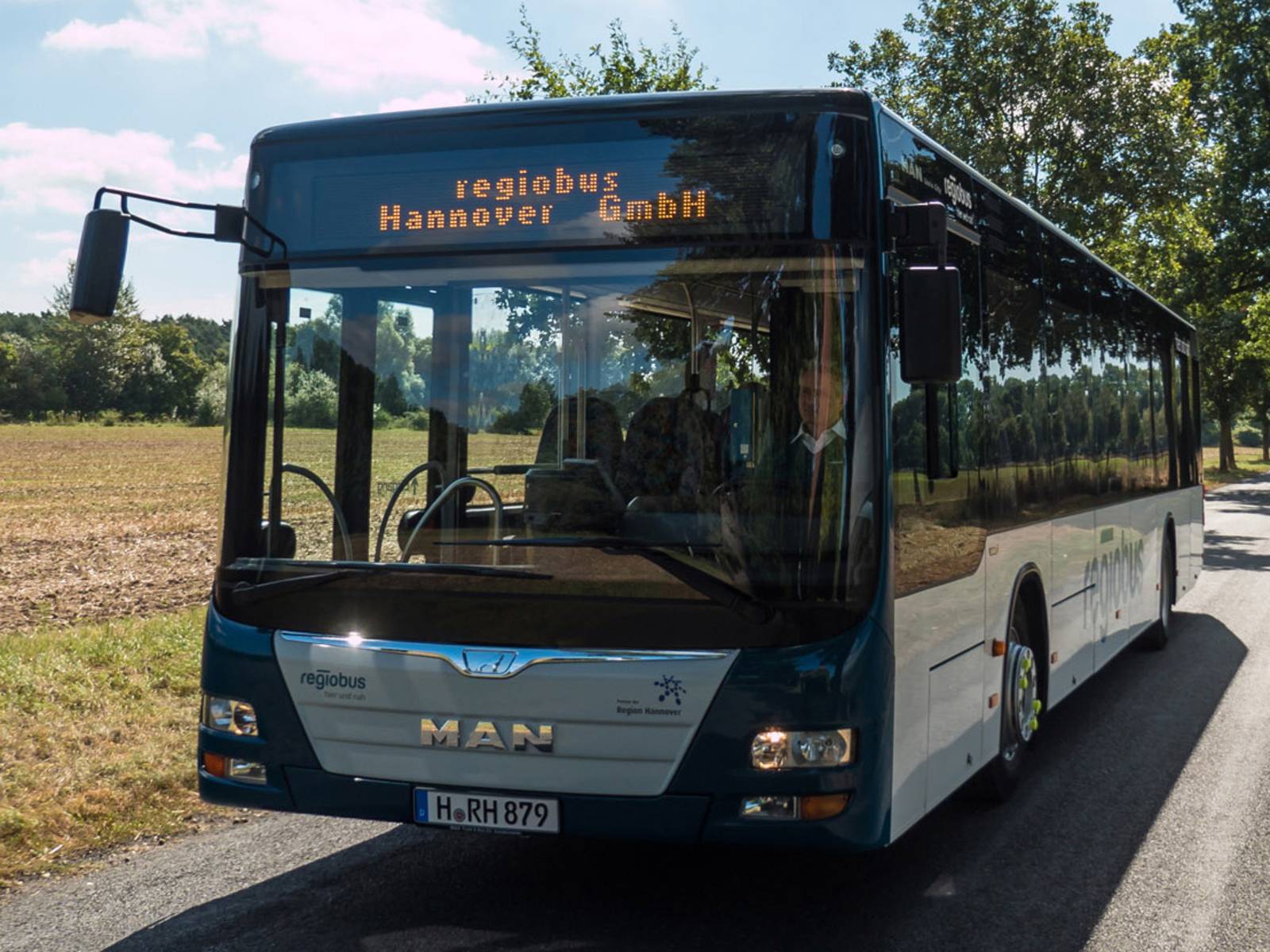 Ein Bus fährt durch eine sommerliche Landschaft