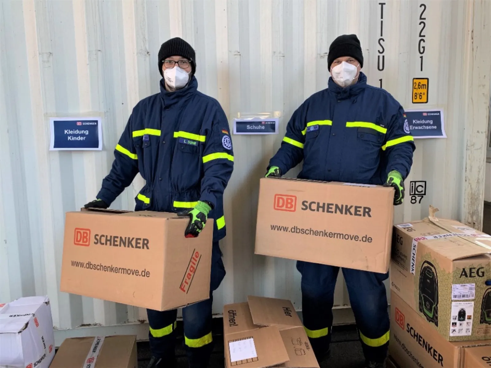 Zwei Männer halten Kartons mit Sachspenden für Geflüchtete