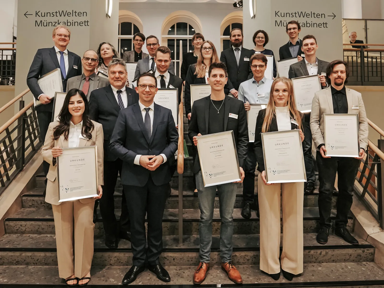 Menschengruppe, einigen halten Urkunden in den Händen.