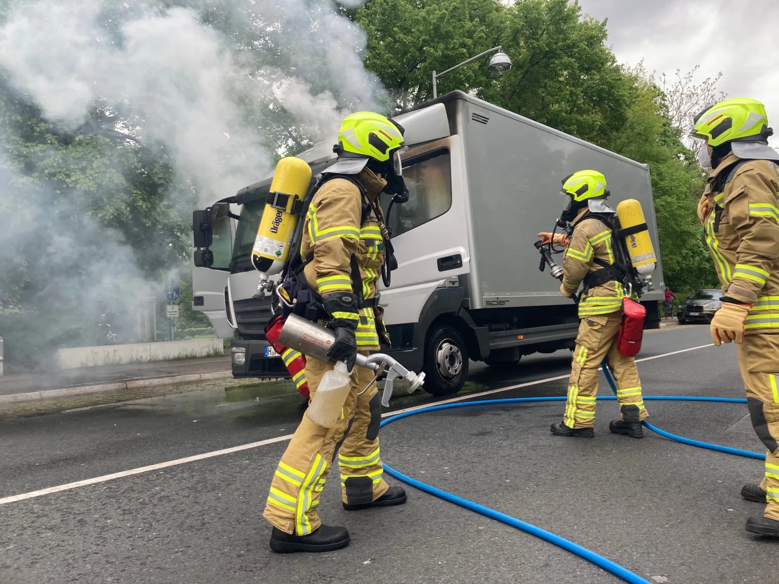 Feuerwehrleute löschen einen LKW.
