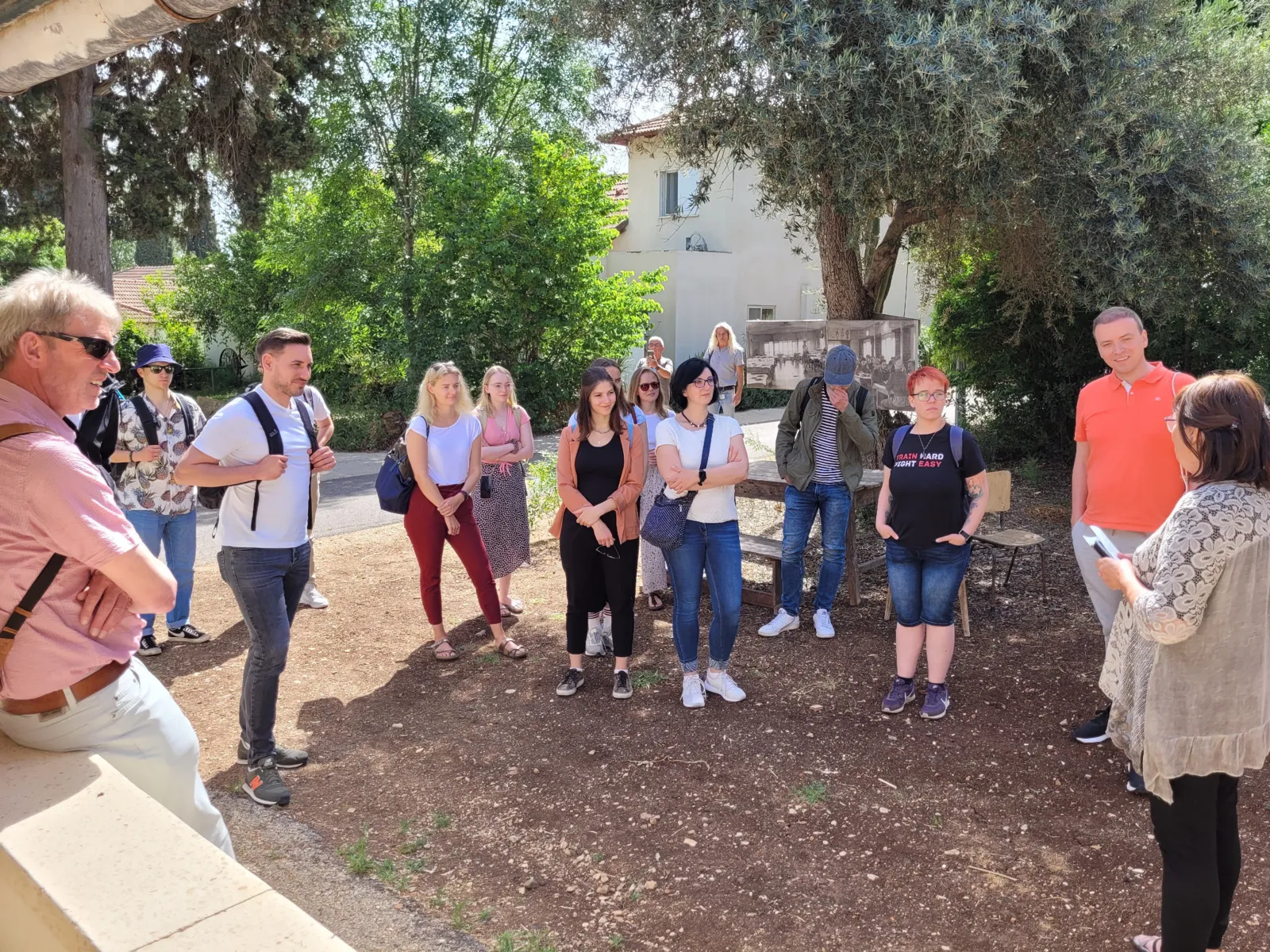 Eine Gruppe von Menschen lauscht den Ausf&uuml;hrungen einer Dame