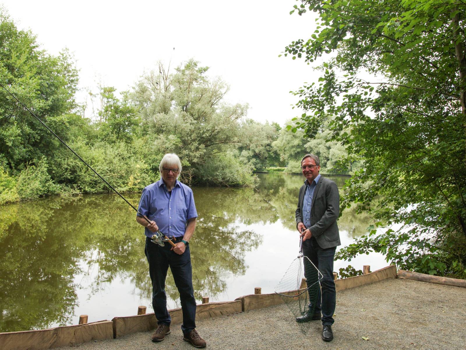 Zwei Personen vor einem Gewässer.