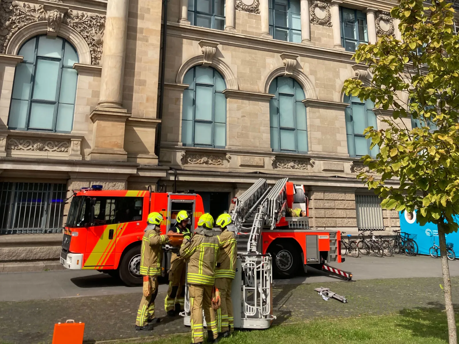Feuerwehrleute und ein Feuerwehrauto vor einem Haus