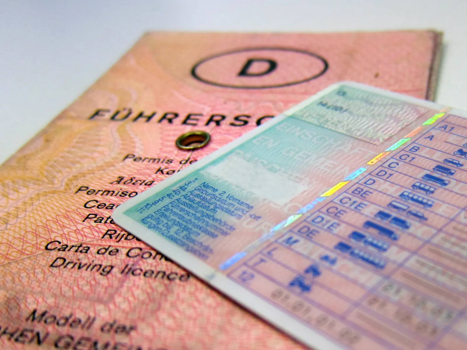 Ein alter deutscher Führerschein, der von einem aktuellen EU-Kartenführerschein teilweise verdeckt wird