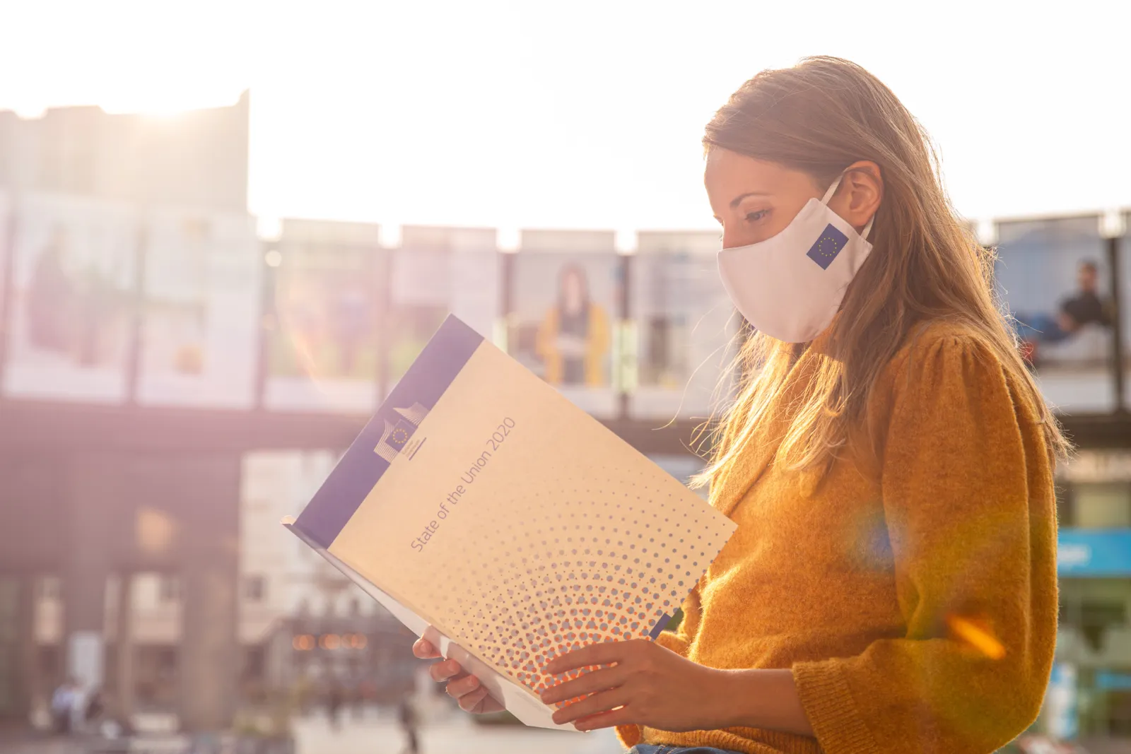 A woman with a face mask holding a folder