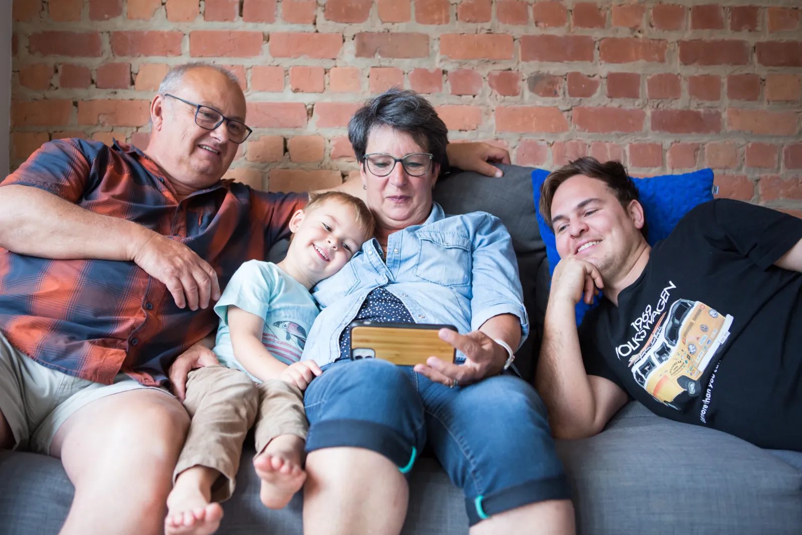 Grandparents watching a video on a smartphone with their grandson