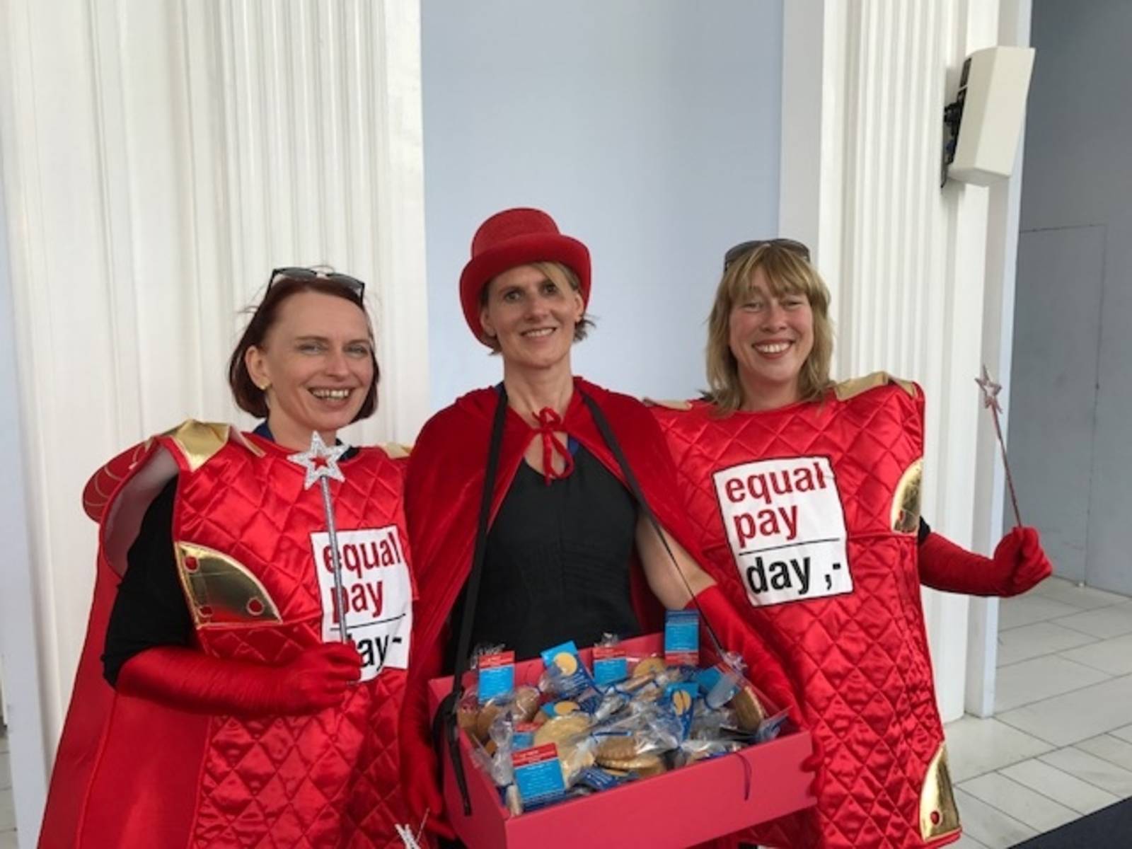 Drei Frauen in roten Kostümen.