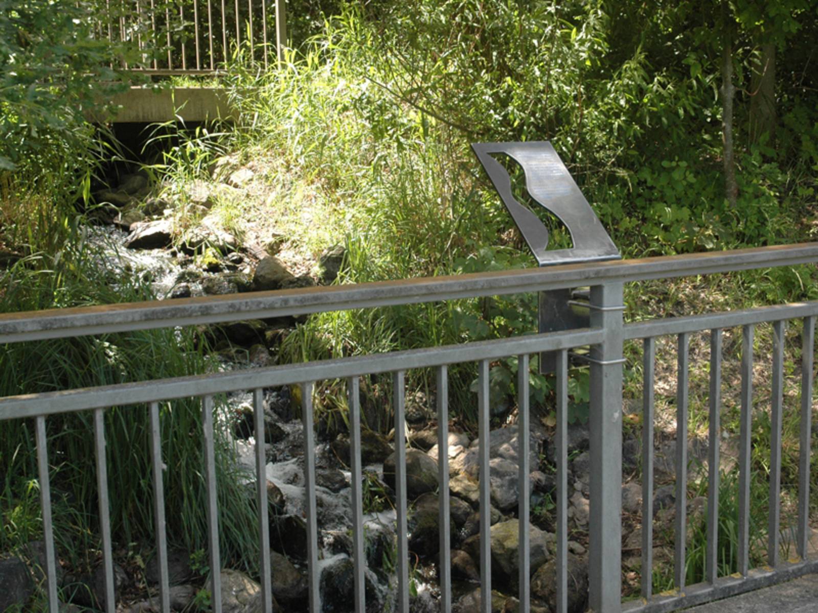 Metalltafel, montiert an einem Brückengeländer