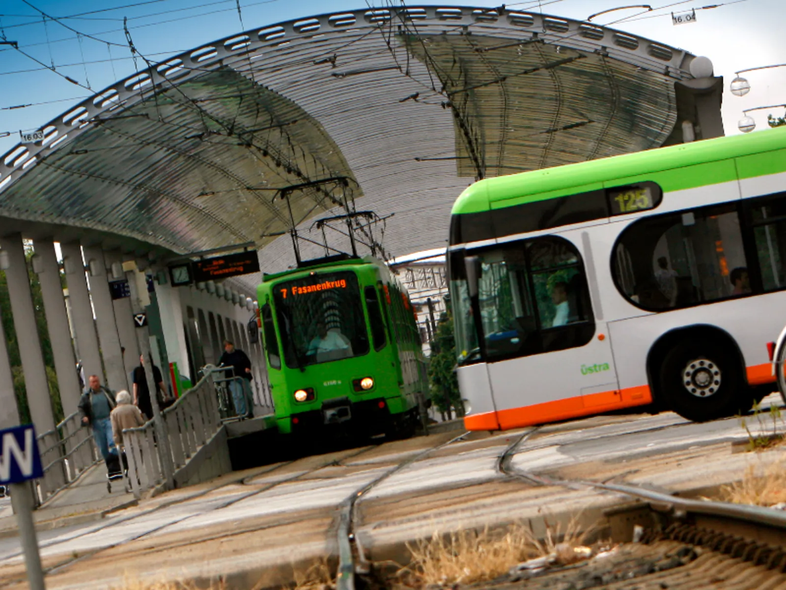 Bus und Bahn kreuzen sich auf einer Hauptverkehrsstraße.