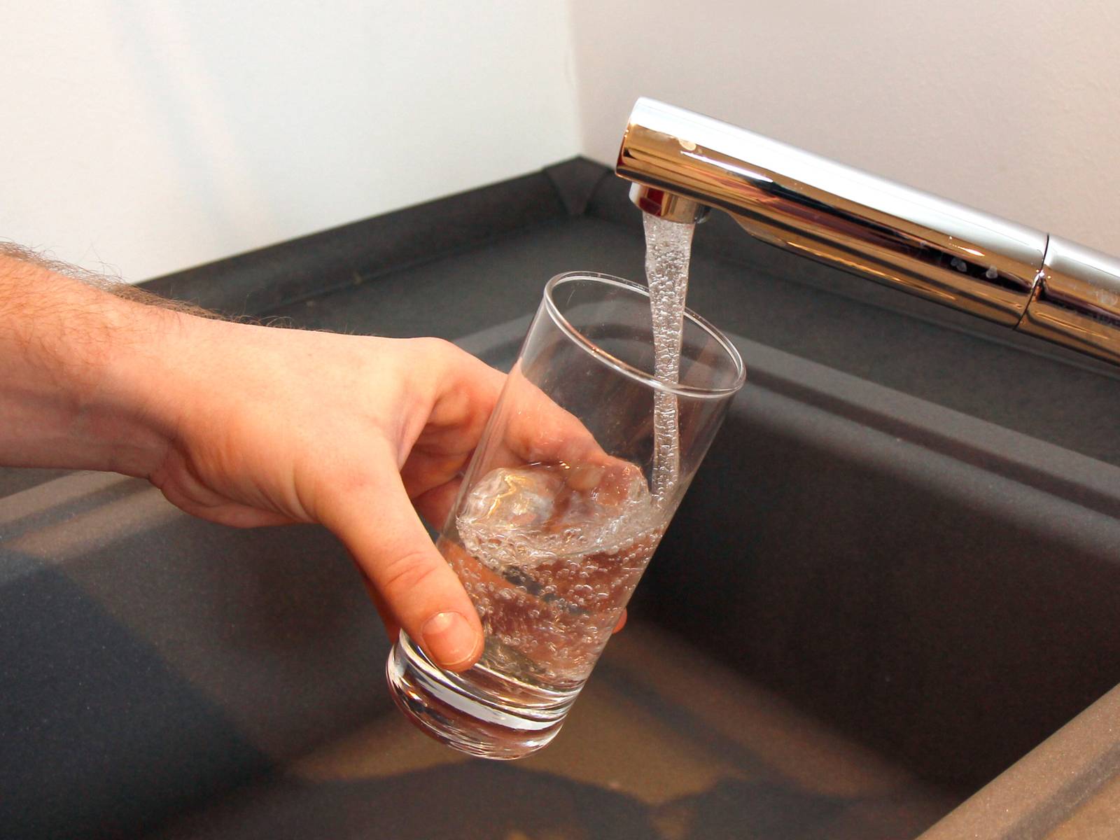 Ein Glas, das mit Wasser aus der Leitung gefüllt wird.