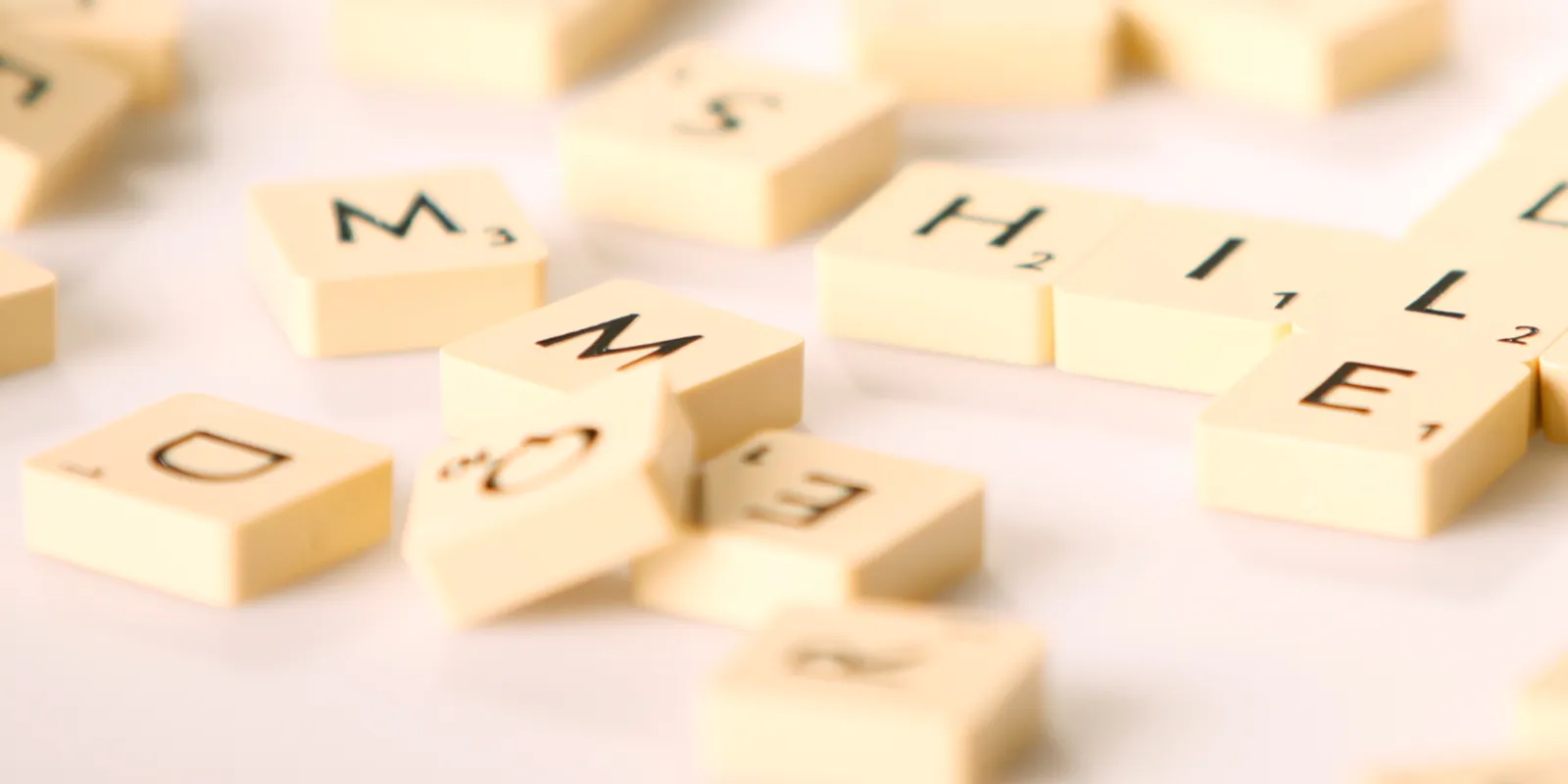 Spielsteine tragen einzelne Buchstaben und liegen durcheinander.